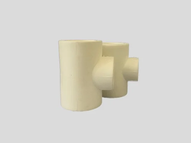 Three white plastic fittings, each with a different size connection, isolated on a gray background.