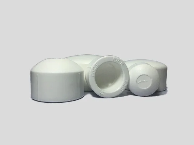 White PVC pipe fittings, including elbows and couplings, arranged on a plain surface.
