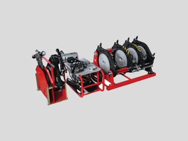 A mechanical device with red metal frame, electronic components, and three circular saw blades mounted on a black base.