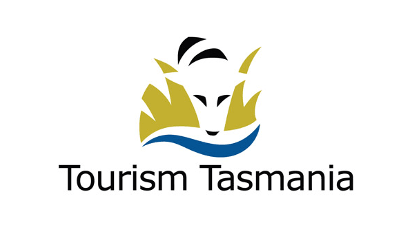 Logo of Tourism Tasmania featuring a stylized face of a Tasmanian devil with green and black accents and blue waves beneath, with the text 'Tourism Tasmania'.