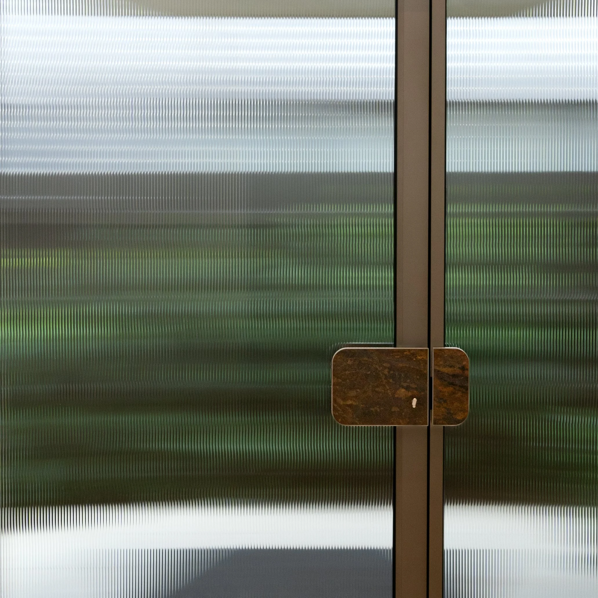 Fluted glass entry door with bespoke pull handle detail, residence