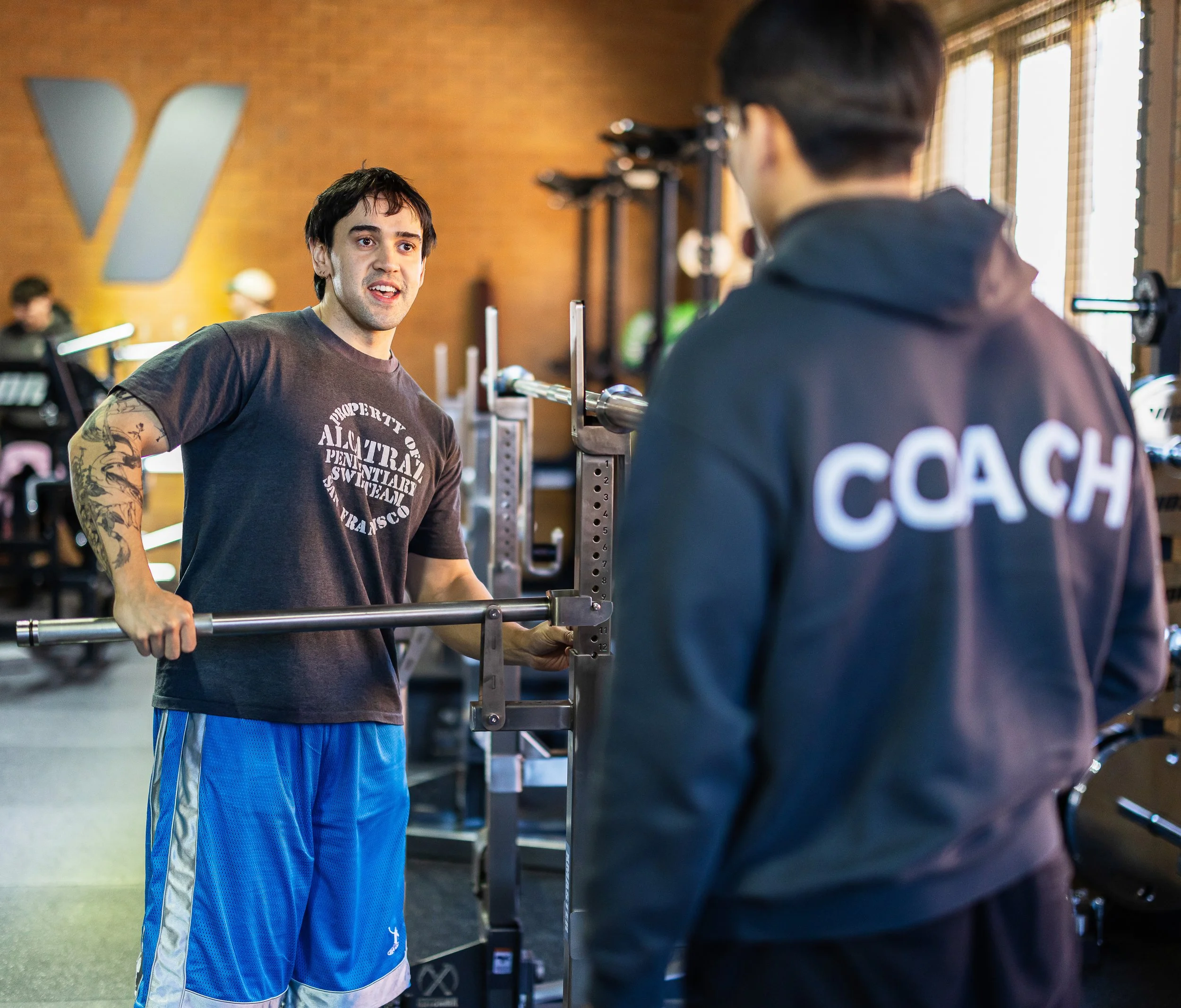 Picture of a member being coached by a staff member with the staff members back turned.