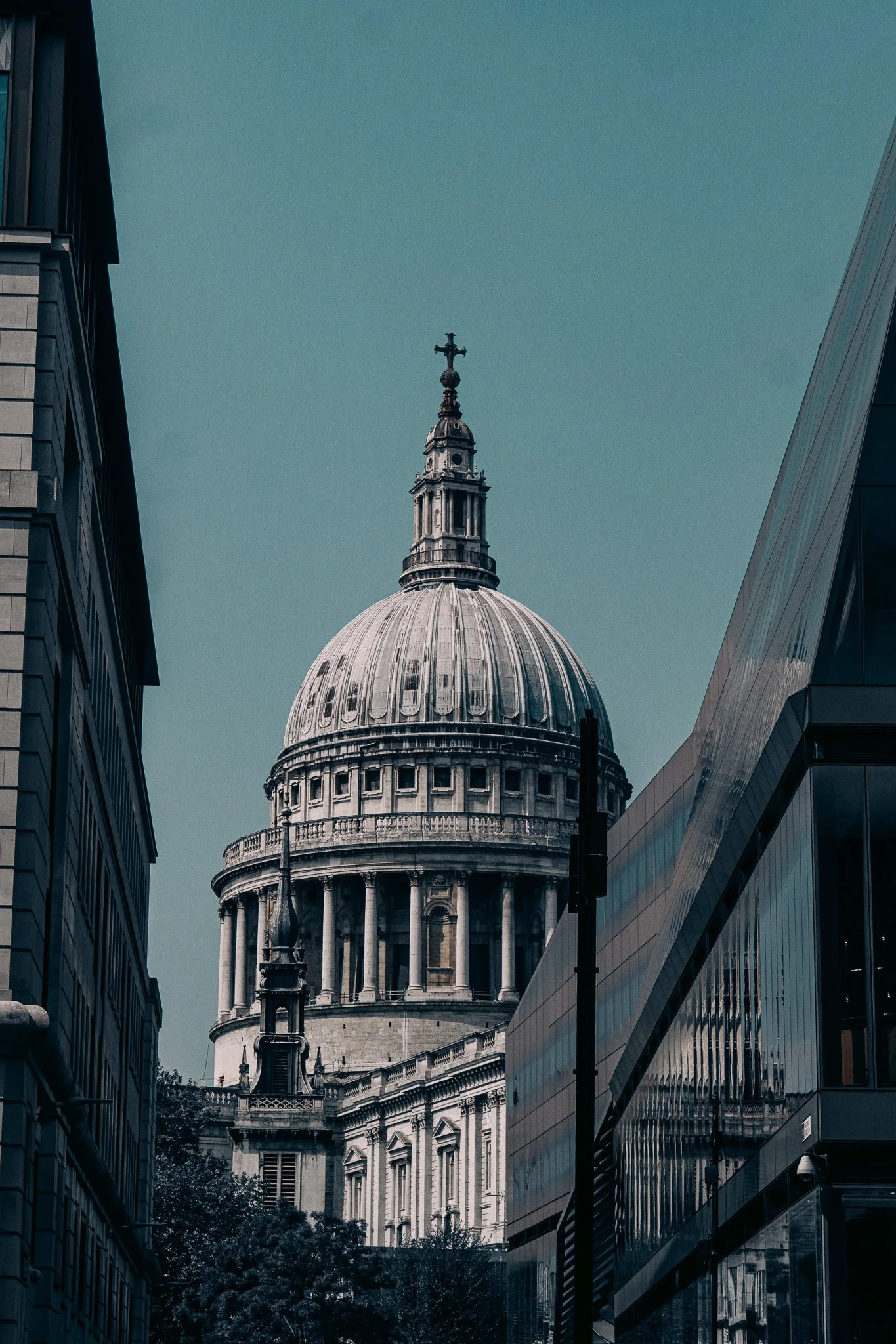 View of St. Paul's Cathedral in London, viewed between modern glass buildings.
