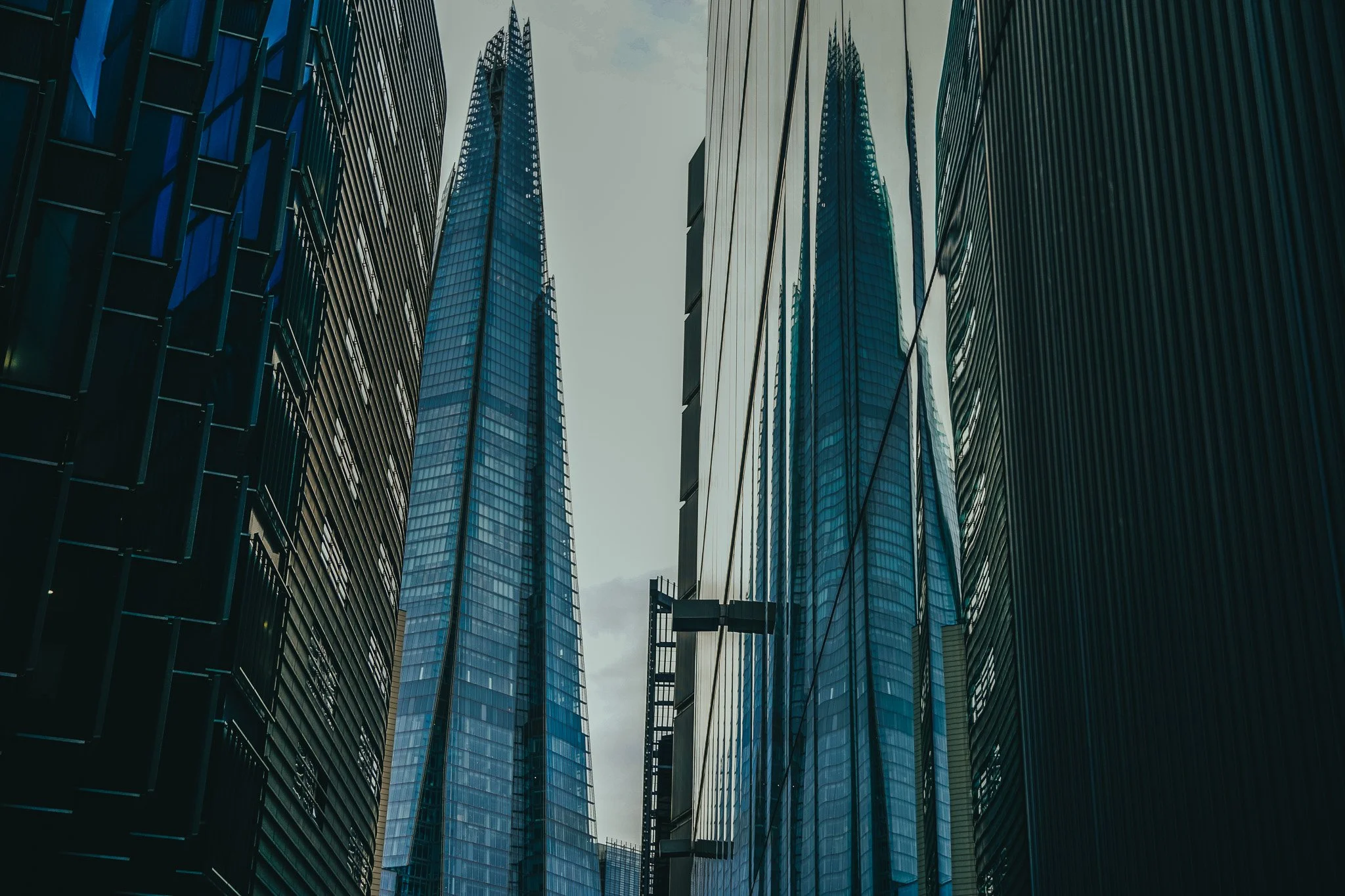 View of tall modern skyscrapers with glass facades in a city skyline, looking up from street level.