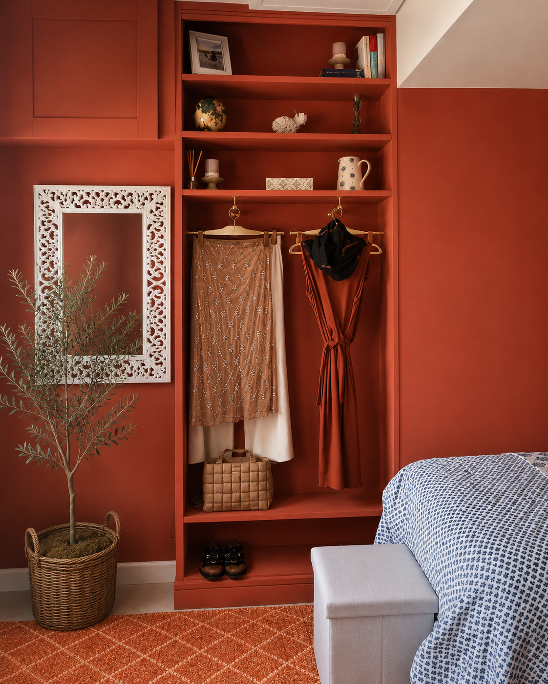 Neptune Rhubarb painted floor-to-ceiling built-in shelving and open wardrobe with brass rail, carved white mirror and olive tree, twin guest bedroom Suffolk