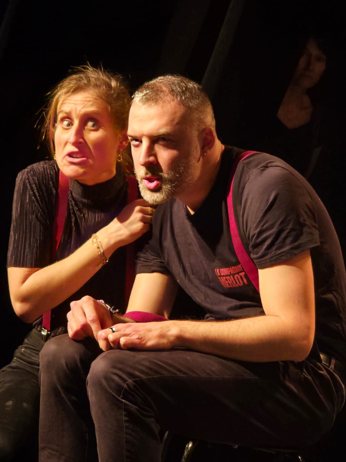 Deux personnes, homme et femme, avec expressions intenses, dans une scène dramatique ou théâtrale.