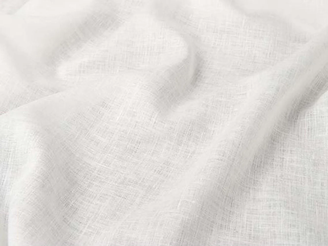 Close-up of white fabric with a smooth and textured appearance, showing gentle folds and subtle shadows.
