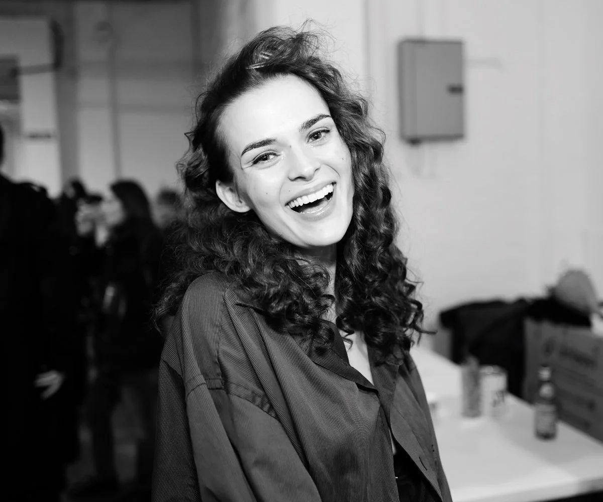 Candid editorial fashion photograph taken backstage during a fashion show