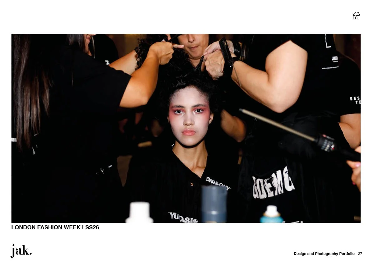 Fashion model sitting with makeup artists and hairstylists during London Fashion Week SS26, getting ready for runway.