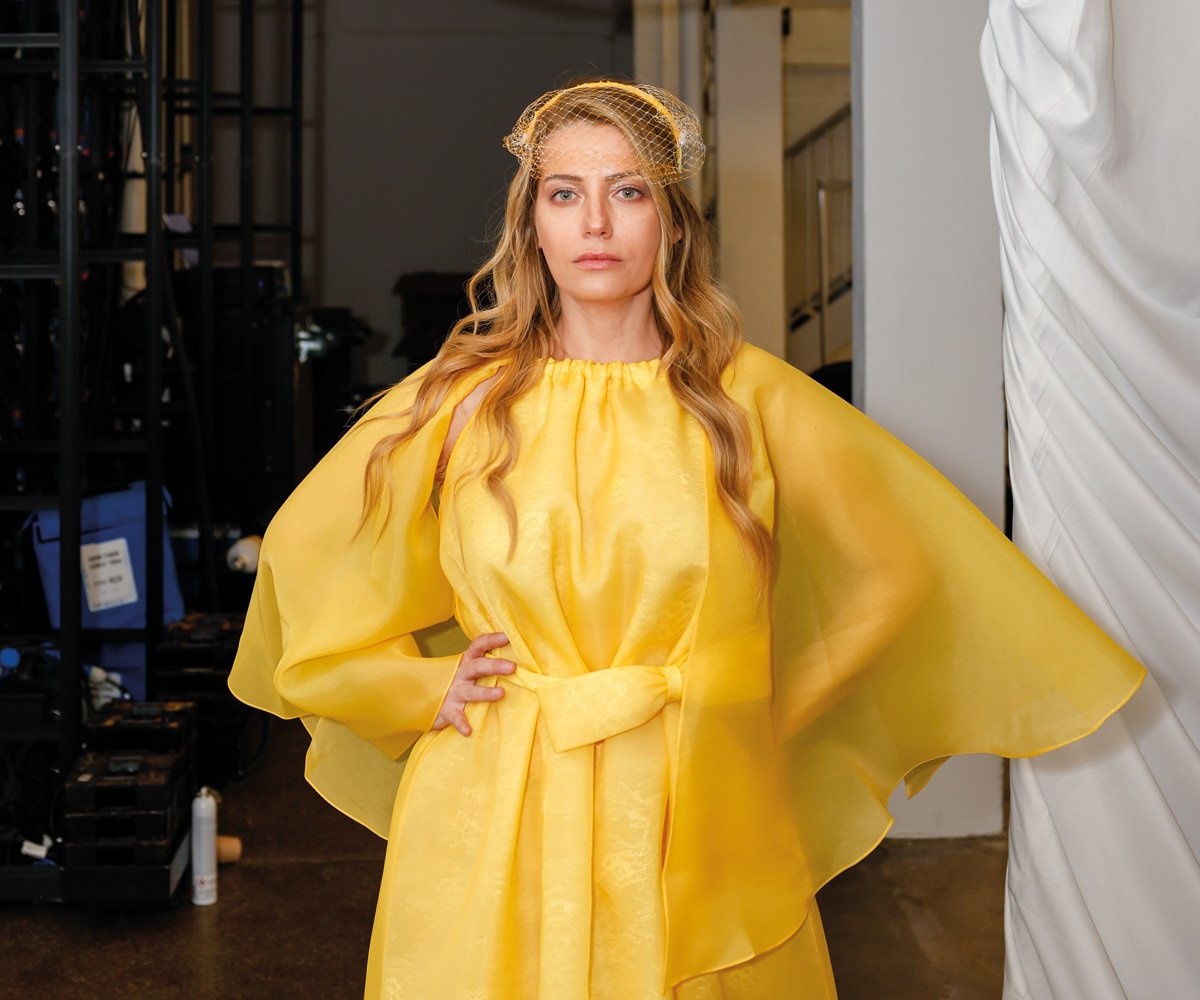 Backstage fashion photography of a model during final preparations ahead of a fashion show