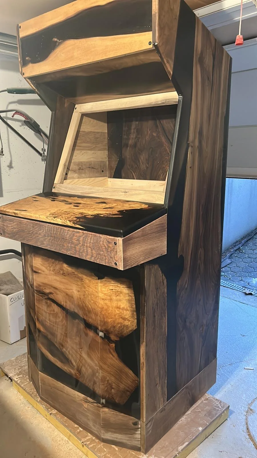 Borne d'arcade en bois et résine avec un design en bois naturel et résine noire, en cours de fabrication.