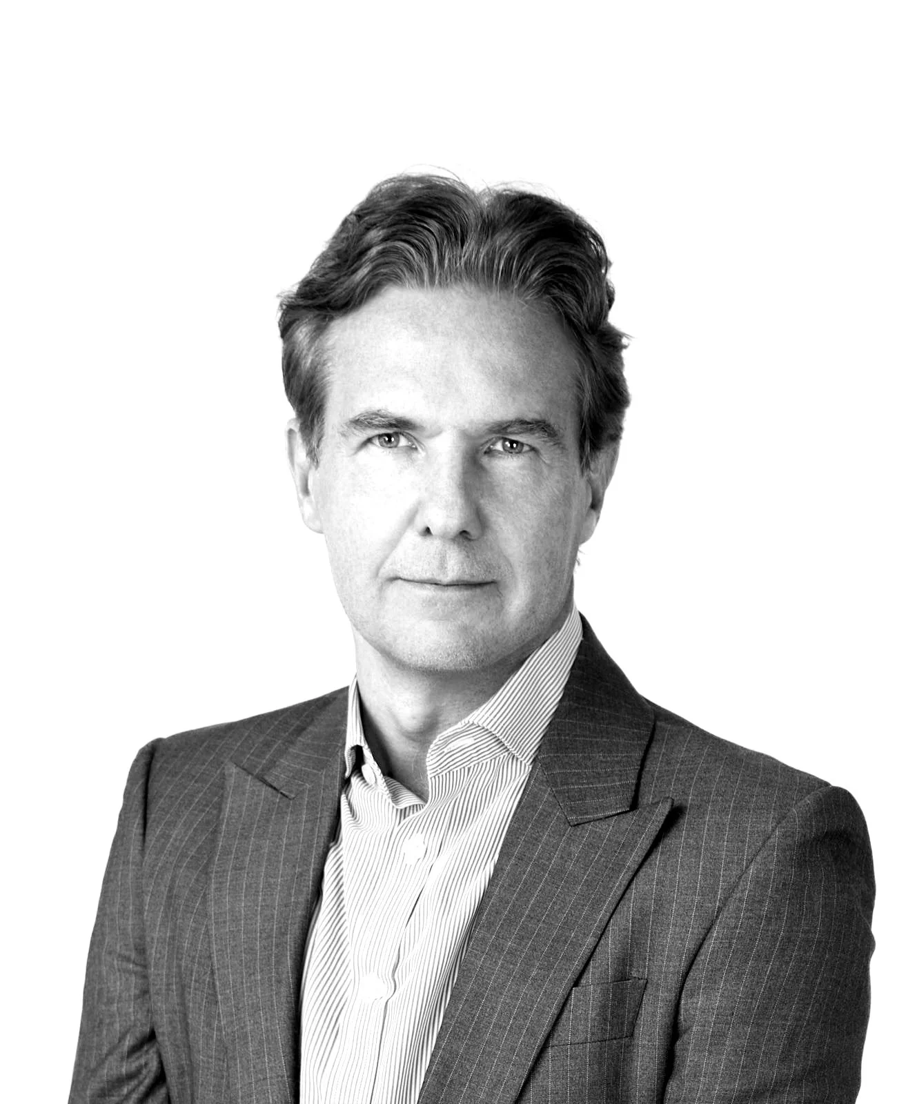 Black and white portrait of a man in a suit with wavy hair, looking confidently at the camera.
