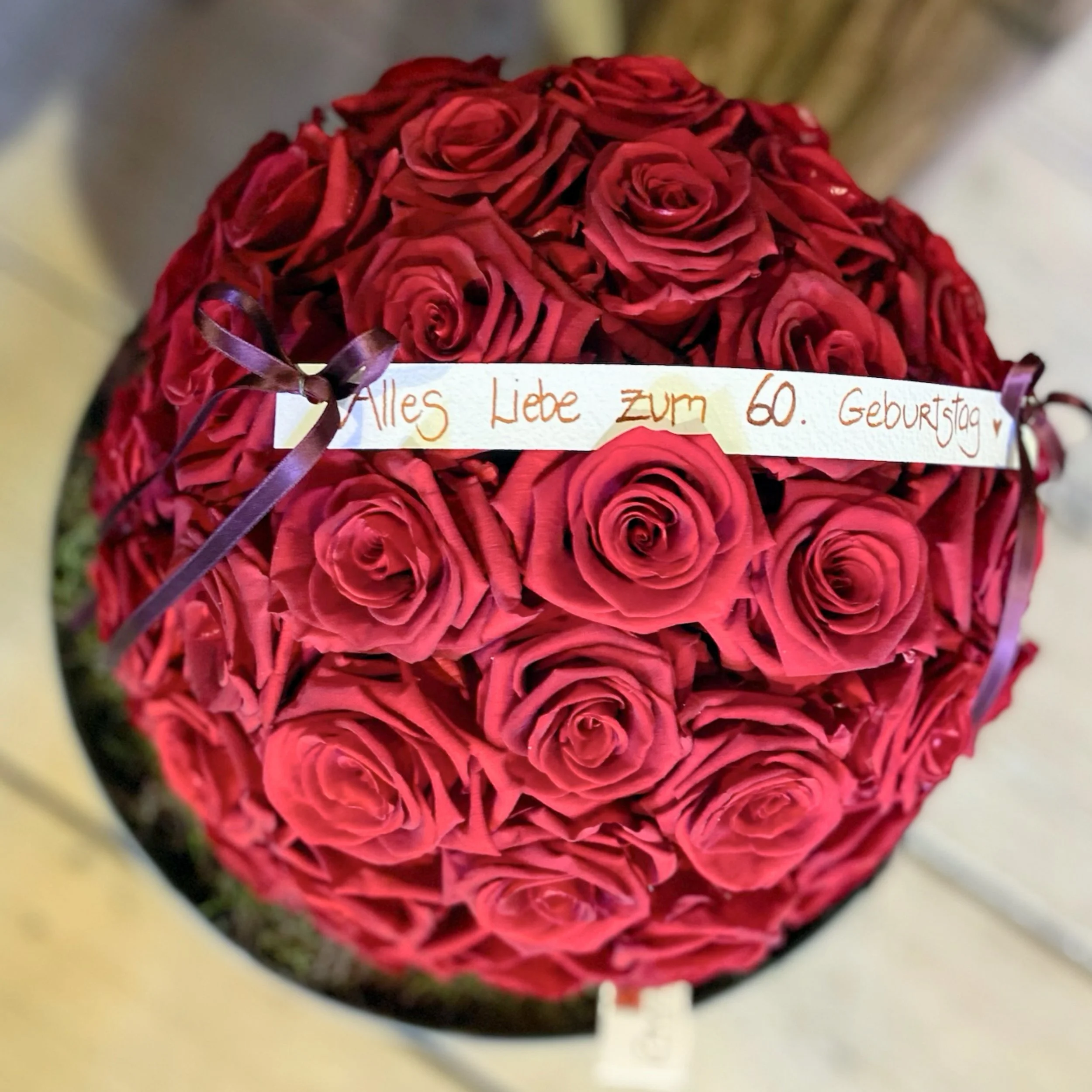 Blumengeschenk mit roten Rosen, mit Handschriftlichem Grußzettel.