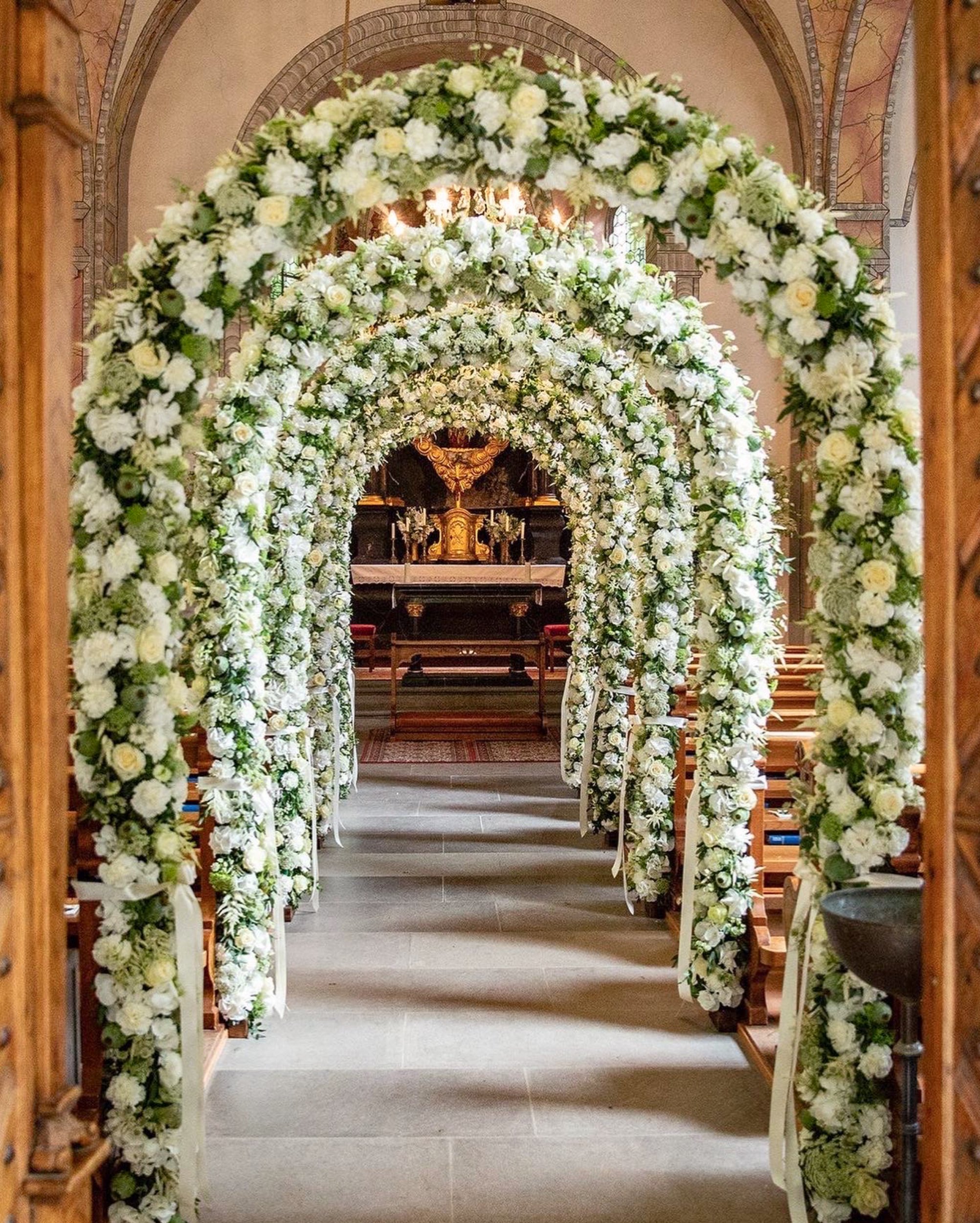 Blumenbogen und Dekoration in einer Kirche für eine Hochzeitszeremonie.