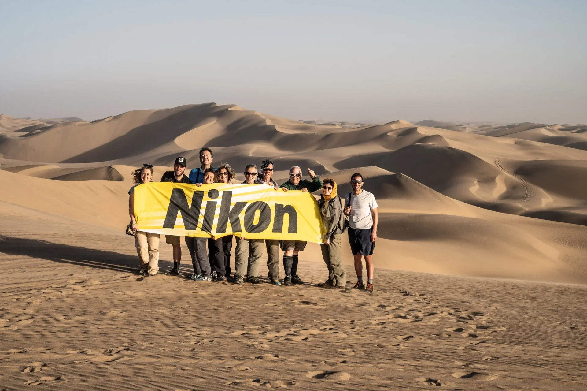Namibia gruppo con banner Nikon School durante viaggio fotografico di Elisabetta Rosso