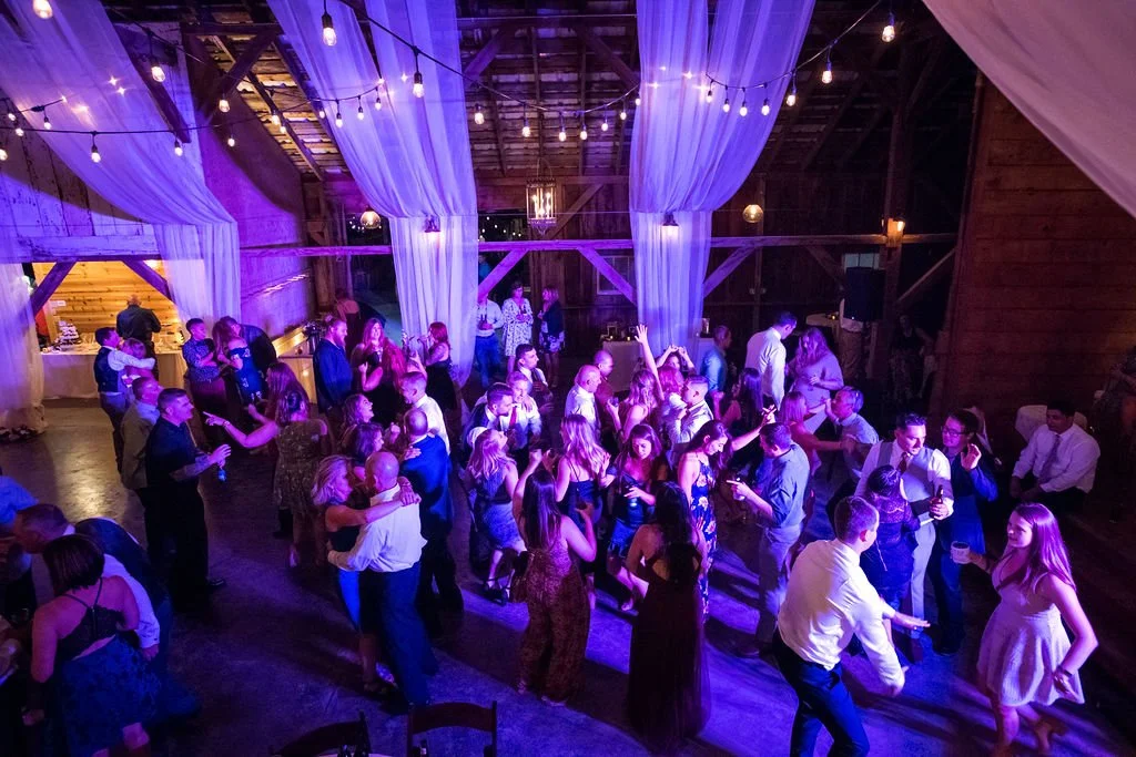 Packed dance floor at a Alabama rustic barn wedding reception with guests of all ages celebrating
