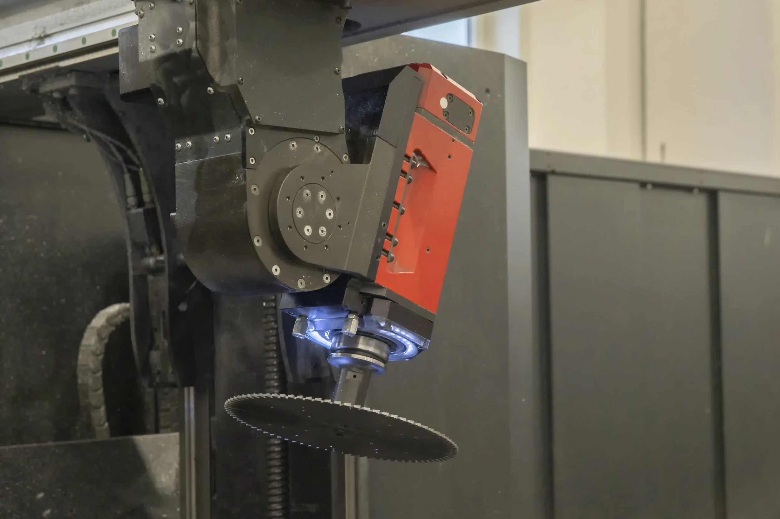 Macchina industriale con parte rossa e un disco dentato sotto