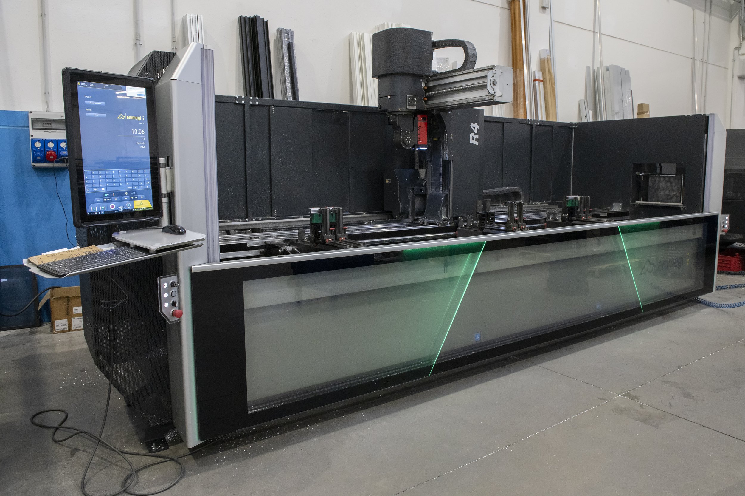 Macchina laser per taglio di vetro o materiali simili con sistema di controllo e computer collegato, in un ambiente industriale.