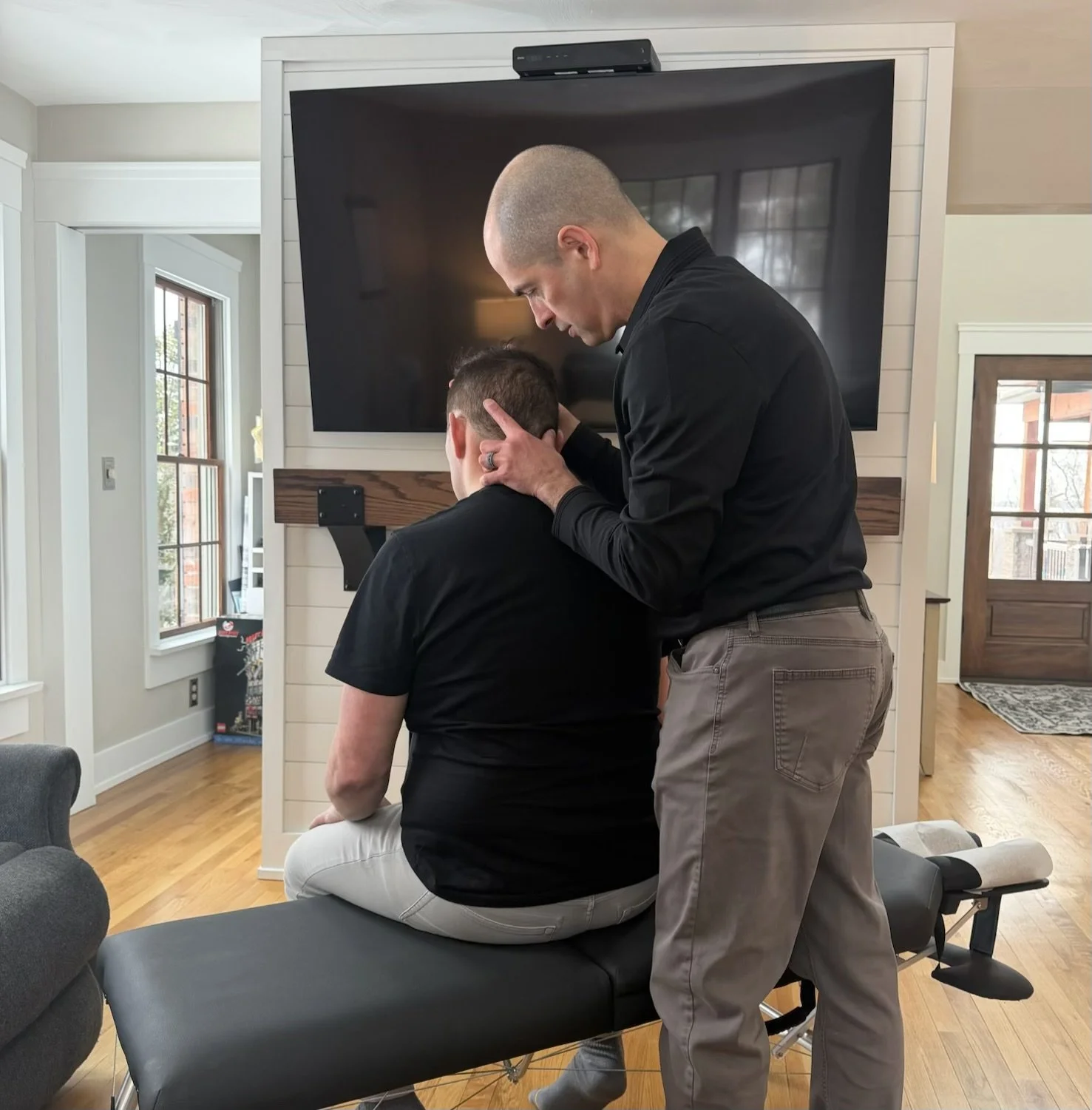 Chiropractor performing adjustments during in-home visits in Westmoreland County, PA.