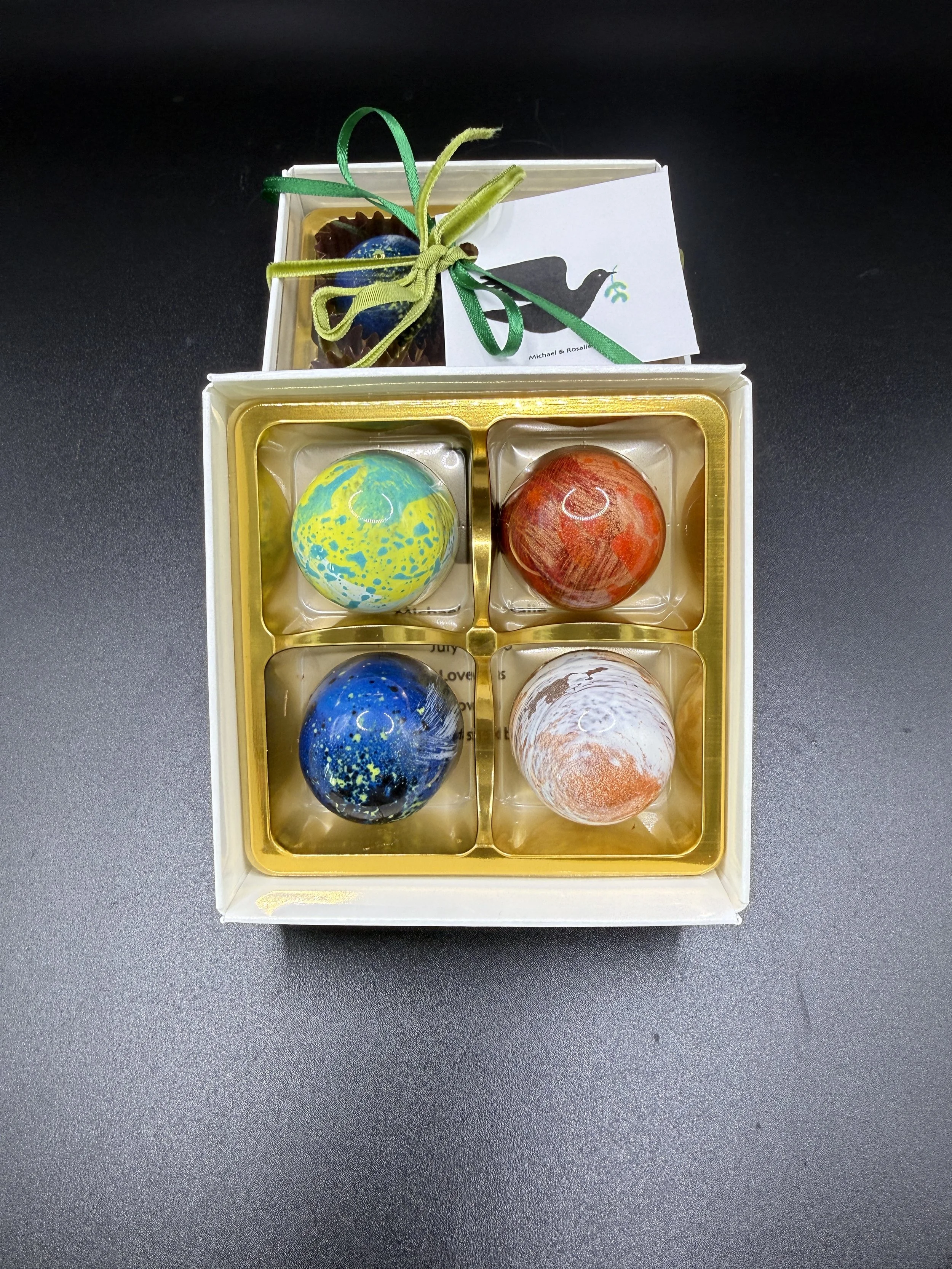 Bespoke gift box of four hand-painted OzMo chocolates presented with a card and ribbon.