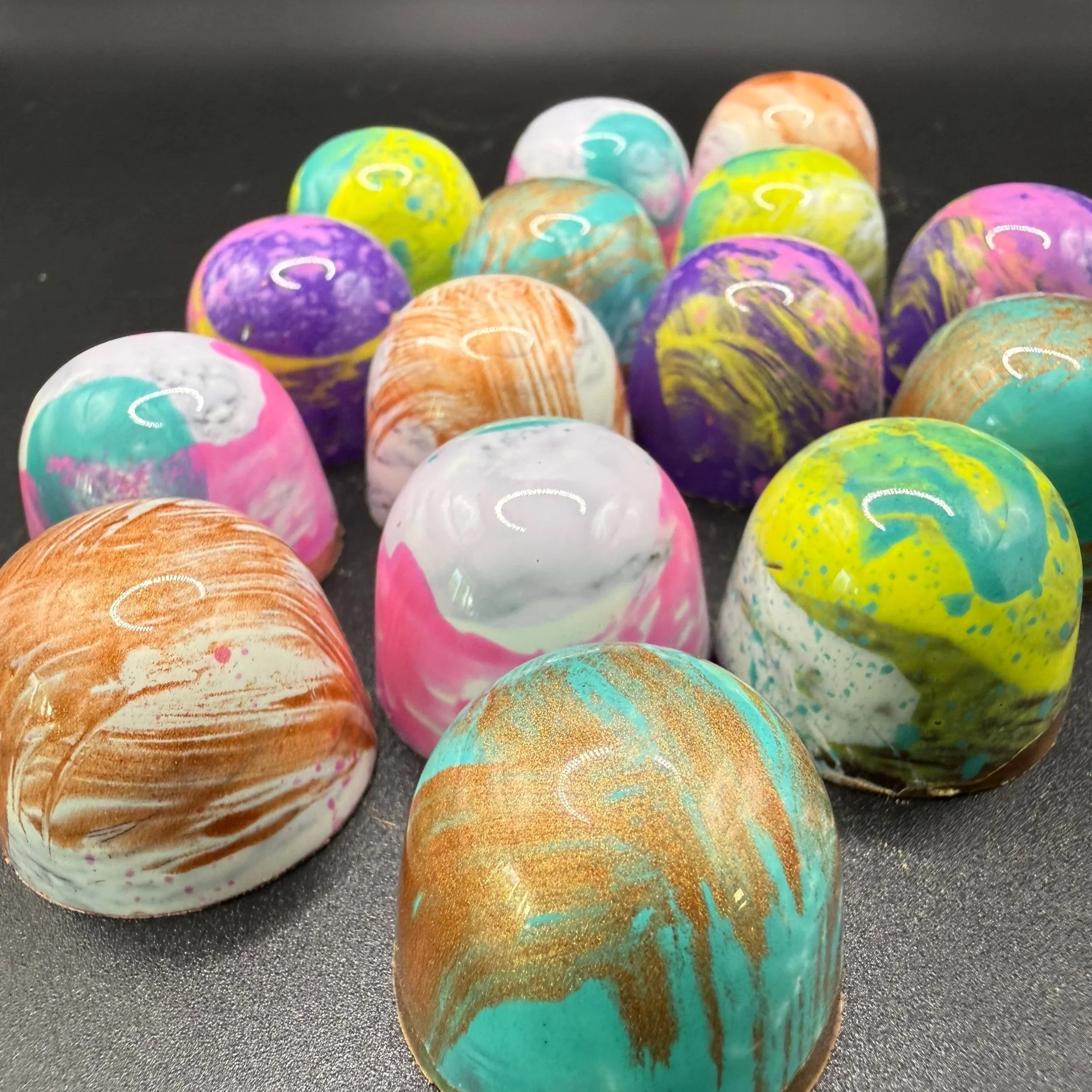 Colourful selection of hand-painted OzMo chocolate bonbons handmade in Somerset.