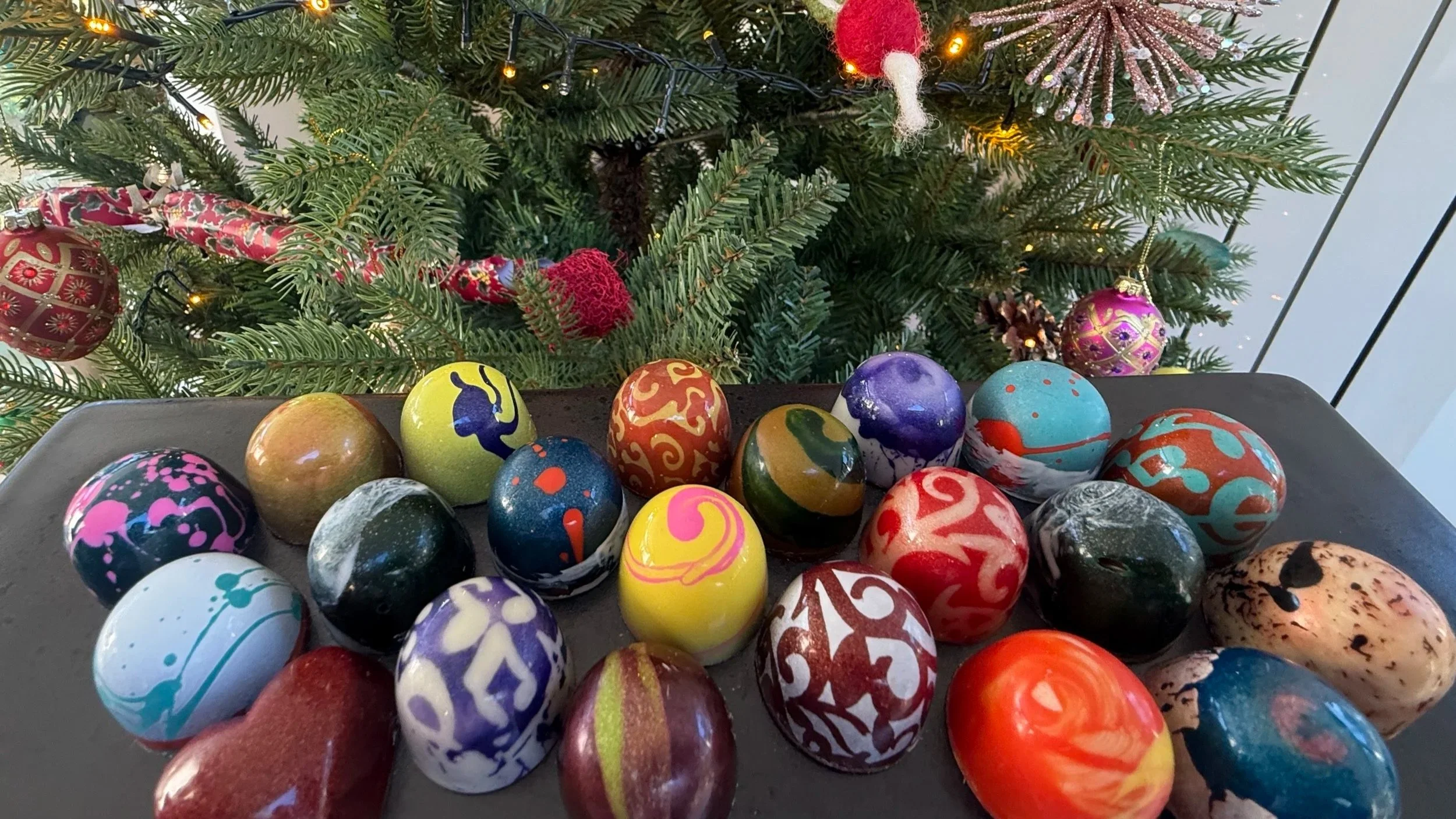 Colourful hand-painted OzMo chocolates displayed for Christmas.