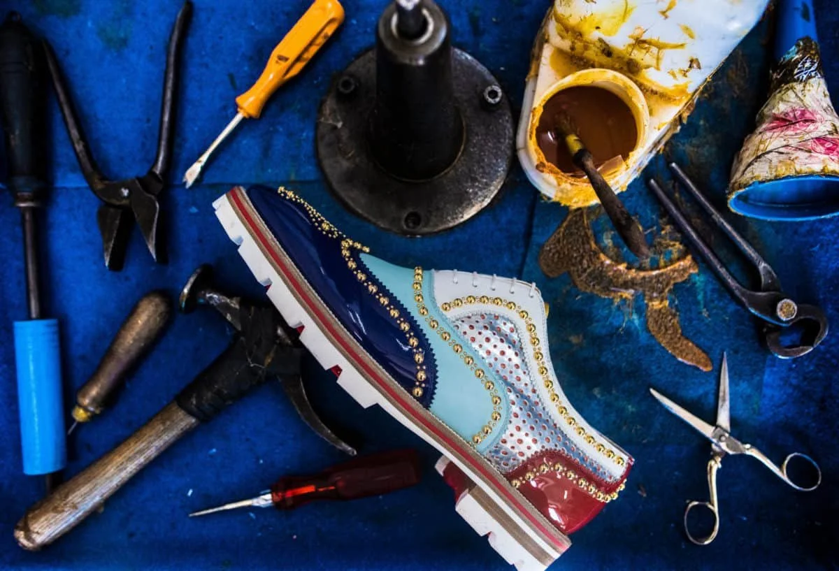 Italian artisan demonstrating luxury shoemaking craftsmanship at Christian Louboutin Naples factory
