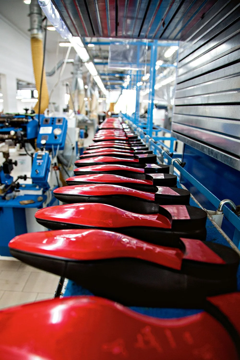 Italian artisan demonstrating luxury shoemaking craftsmanship at Christian Louboutin Naples factory