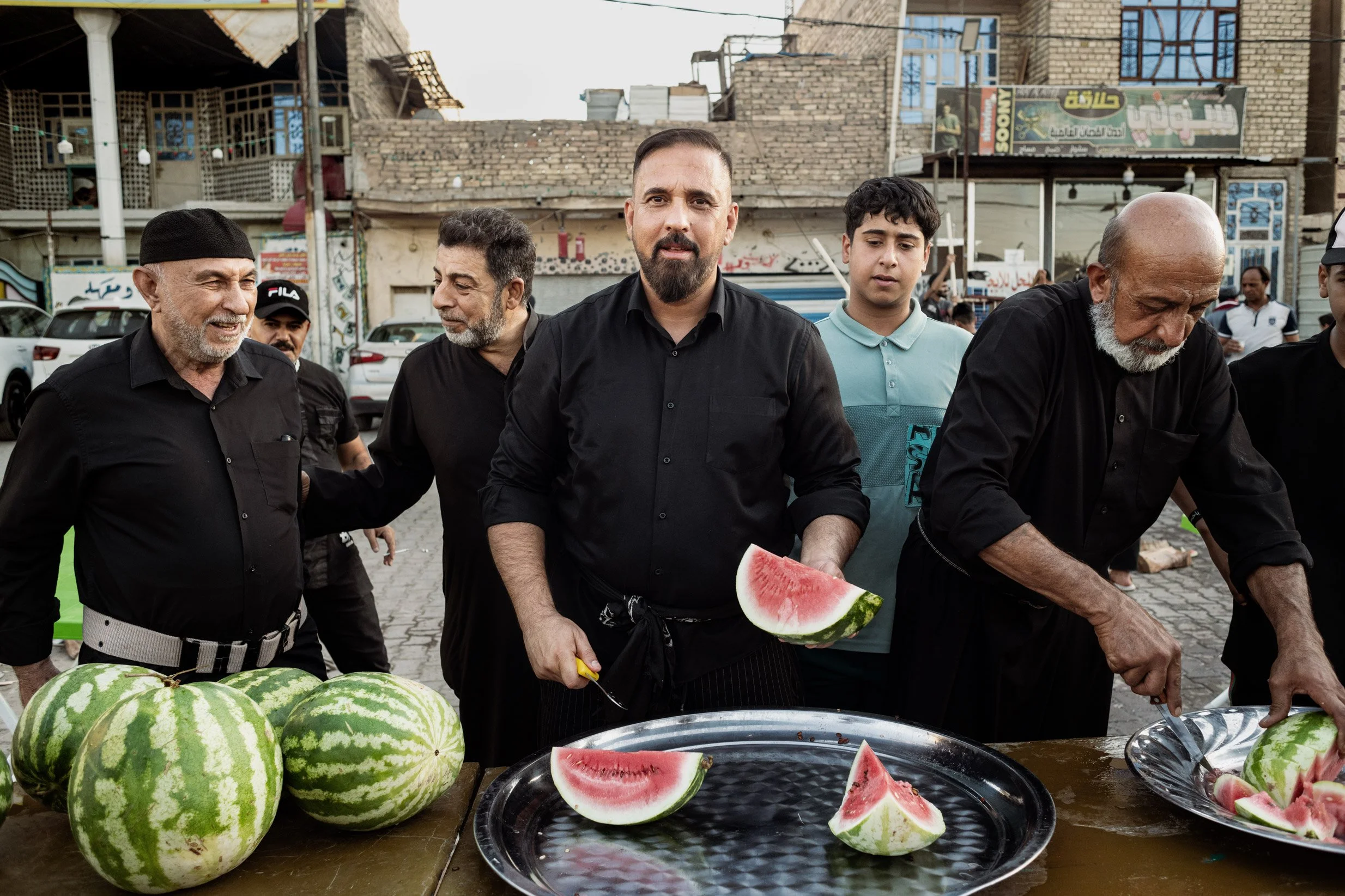 Au 9ème jour de la commémoration d'Ashoura, une famille se regroupe afin de preparer des pastèques qui seront distribuer gratuitement pendant les processions, Sadr City, Iraq, Juillet 2024