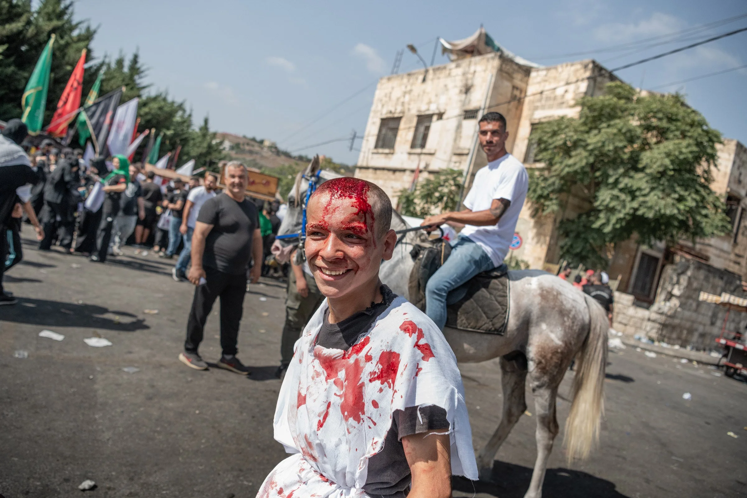Un homme souriant pendant les processions d'Ashura à Nabatiyeh au Liban, 29 Juillet 2023