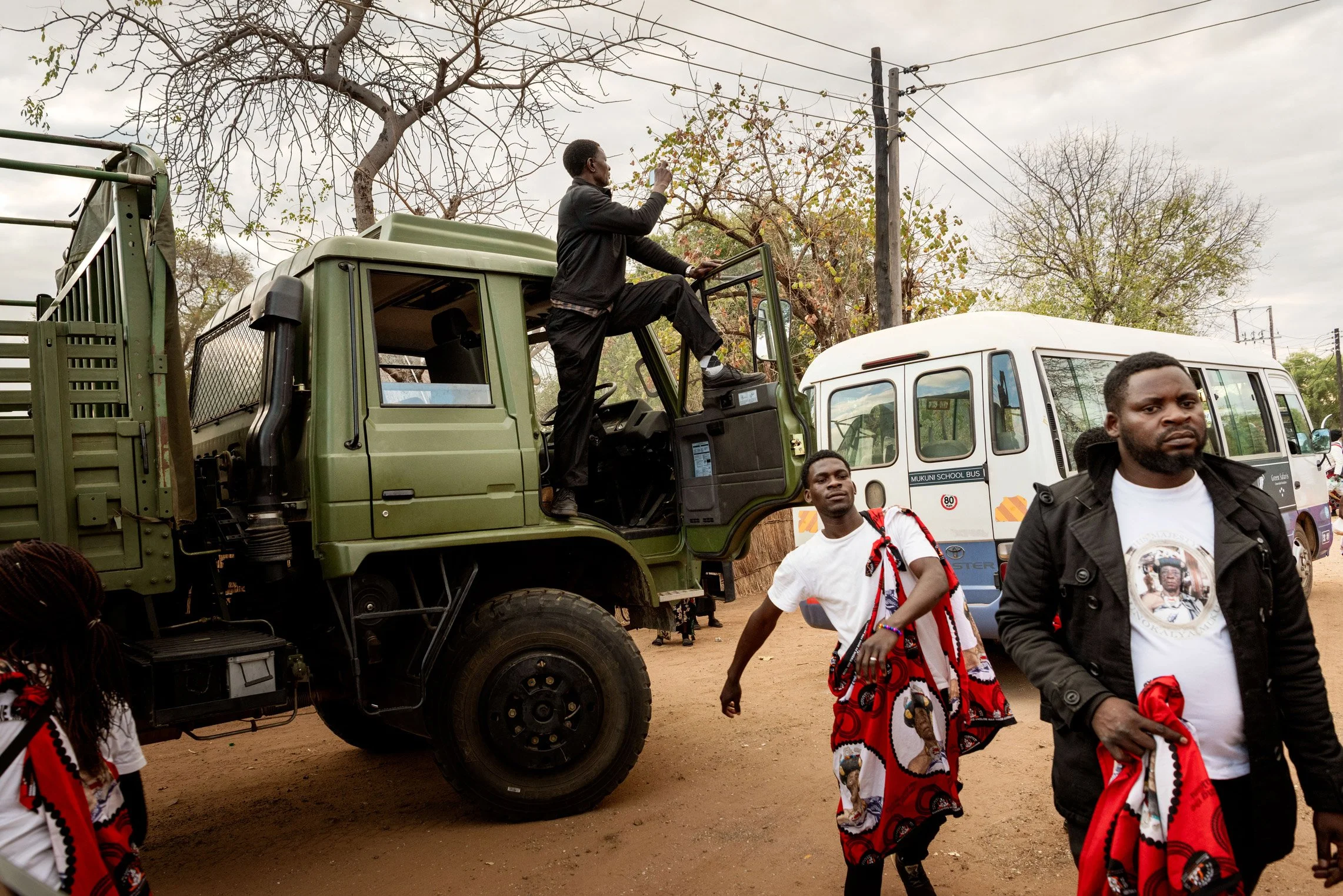 Dernière étape de la manifestation d'annonce du Bene Mukuni cinq jour avant le commencement officiel: les participants débarquent au village de Mukuni habillés du Shitenge traditionnel Toka Leya tandis qu’un homme monte sur un camion afin de filmer l