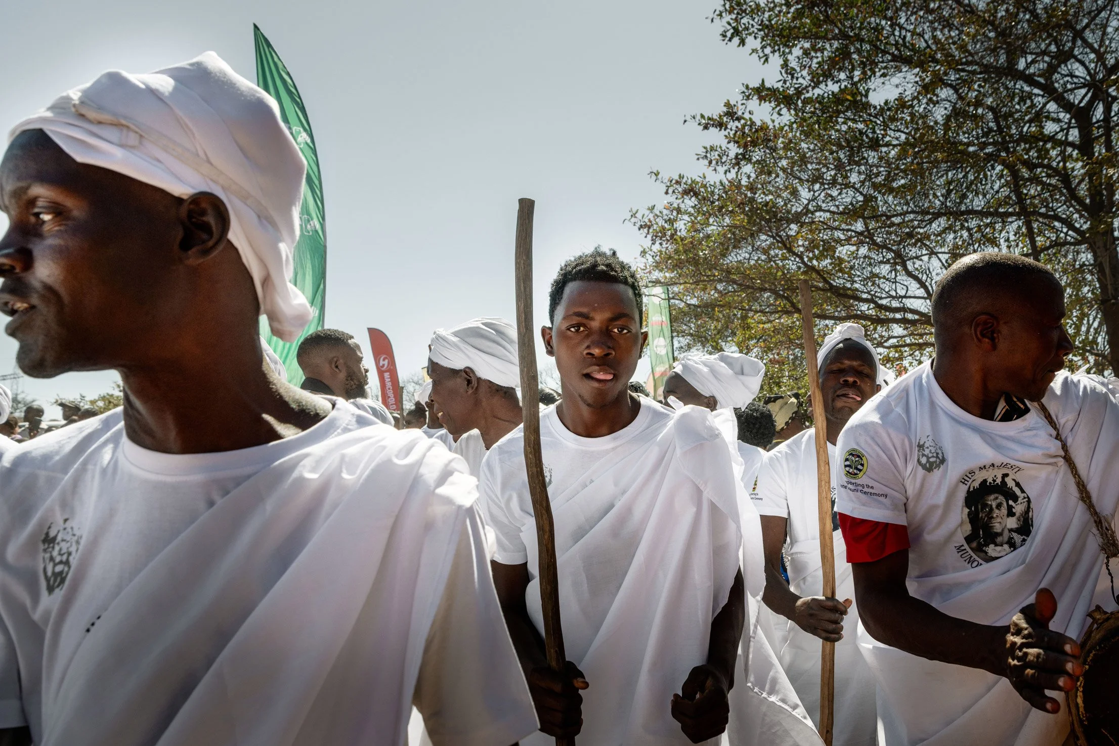 Lors du dernier jour de la cérémonie du Bene Mukuni, des hommes en habits traditionnels avec des lances cérémonielles marchent vers la place central de Simukale, retraçant ainsi le parcours historique de la communauté des Toka Leya. Zambie, Simukale 