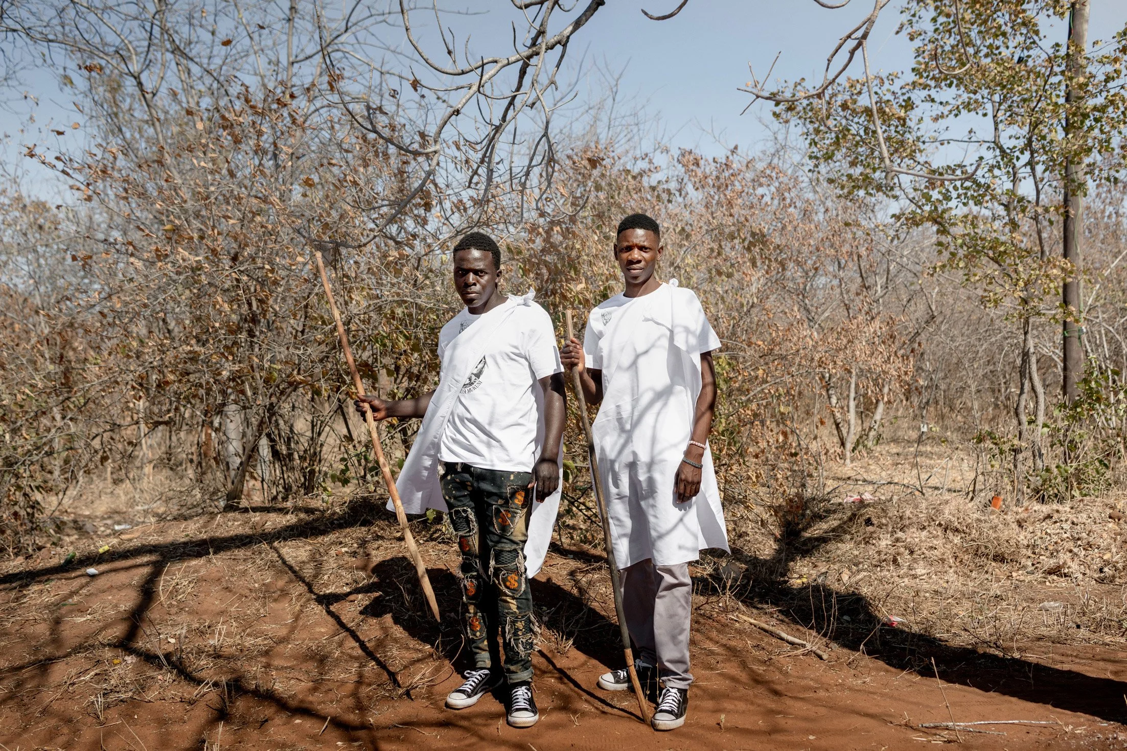 Participants Toka Leya en habits blancs traditionnelle pour le dernier jour de la cérémonie du Bene Mukuni tenant des lances cérémonielles. Zambie, Simukale - 26 Juillet 202
