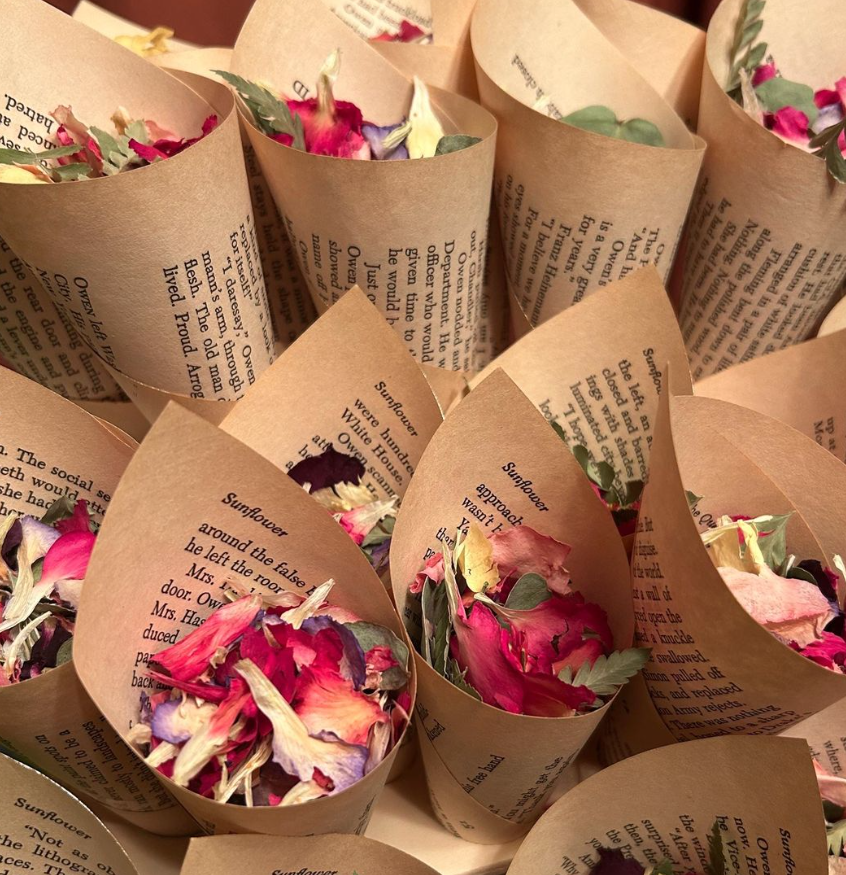 Multiple paper cones filled with dried rose petals and flower petals, arranged in a close-up view.