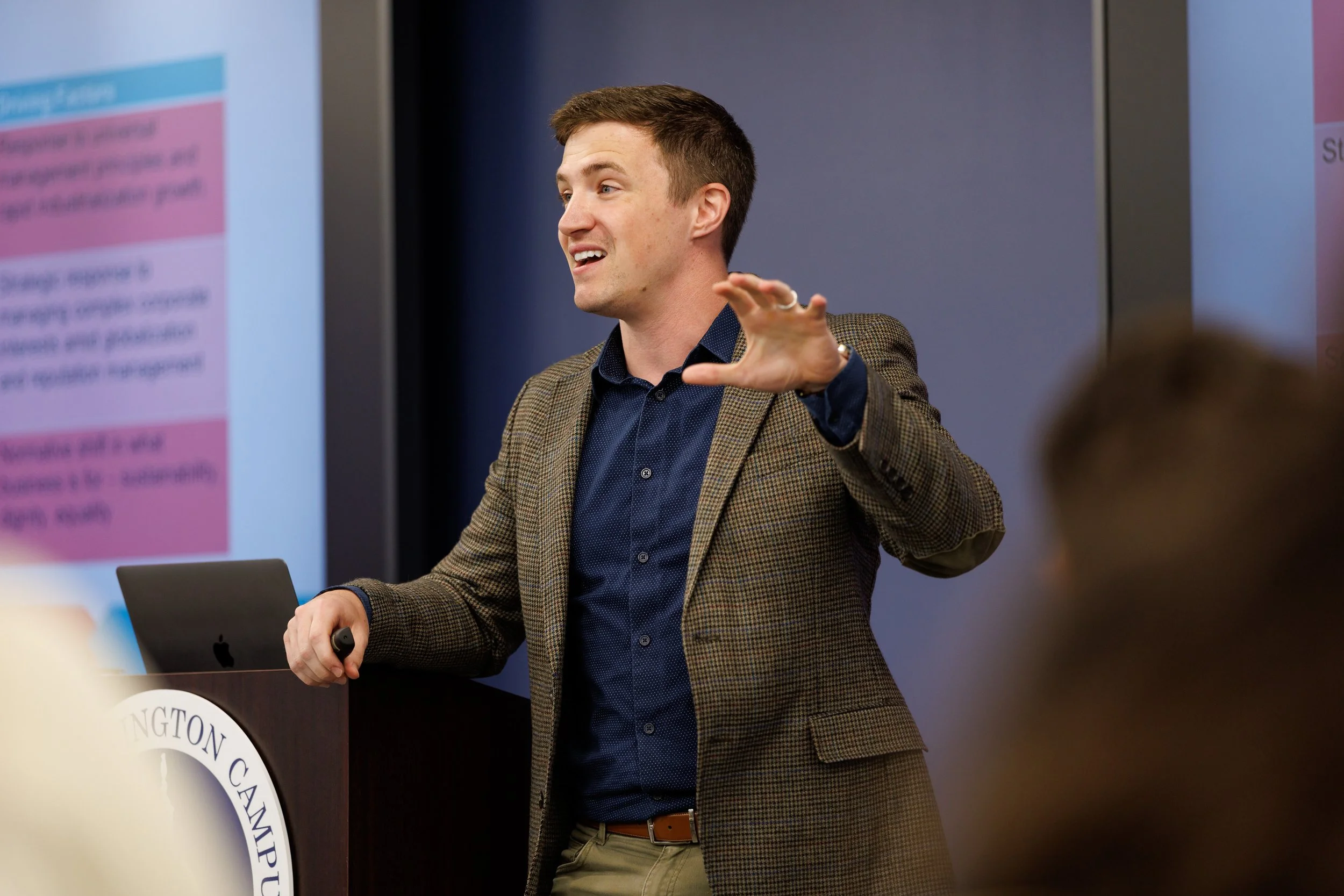 Thomas J. Fewer presenting research on organizations, politics, and public impact at an academic conference.