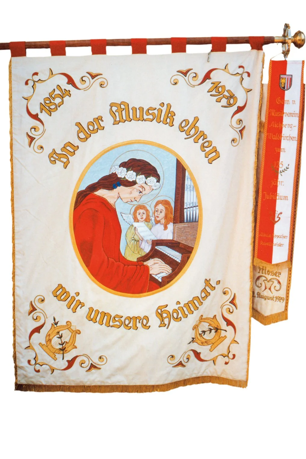 Ein Wandbanner mit dem Text "125 Jahre Jahr der Musik Ehre wir unsere Heimat". Es zeigt eine Illustration von einer Frau mit roten Haaren im roten Kleid, die an einem Klavier spielt, mit zwei Engelsfiguren im Hintergrund. Das Banner ist von einem roten Fransenrand umrundet.