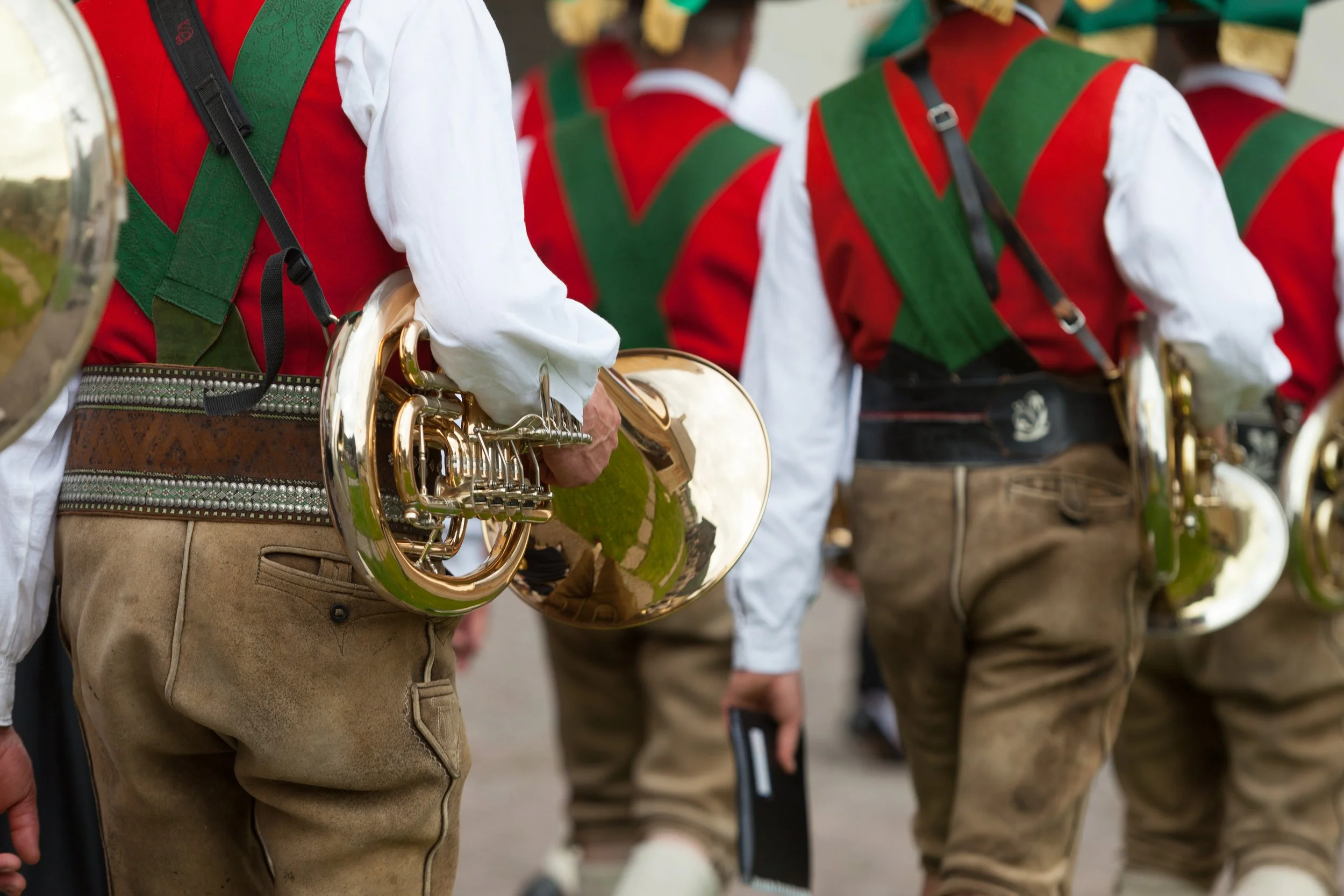 Musiker in traditioneller Kleidung mit Hörnerinstrumenten während eines Festumzugs.