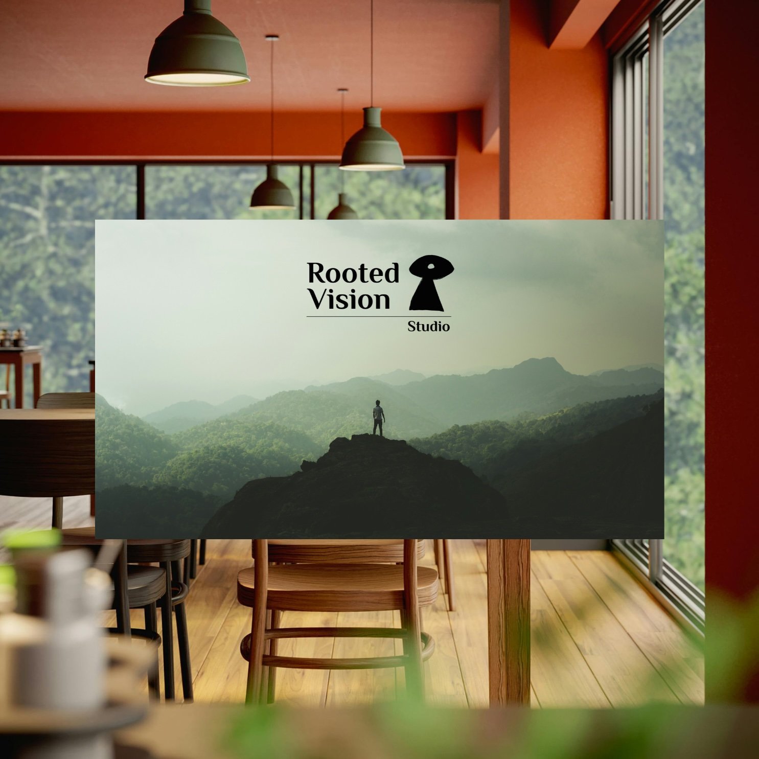 A sign for Rooted Vision Studio features a mountain landscape with a person standing on a rock formation, surrounded by lush green mountains. The sign includes a logo with a keyhole shape and the studio name.