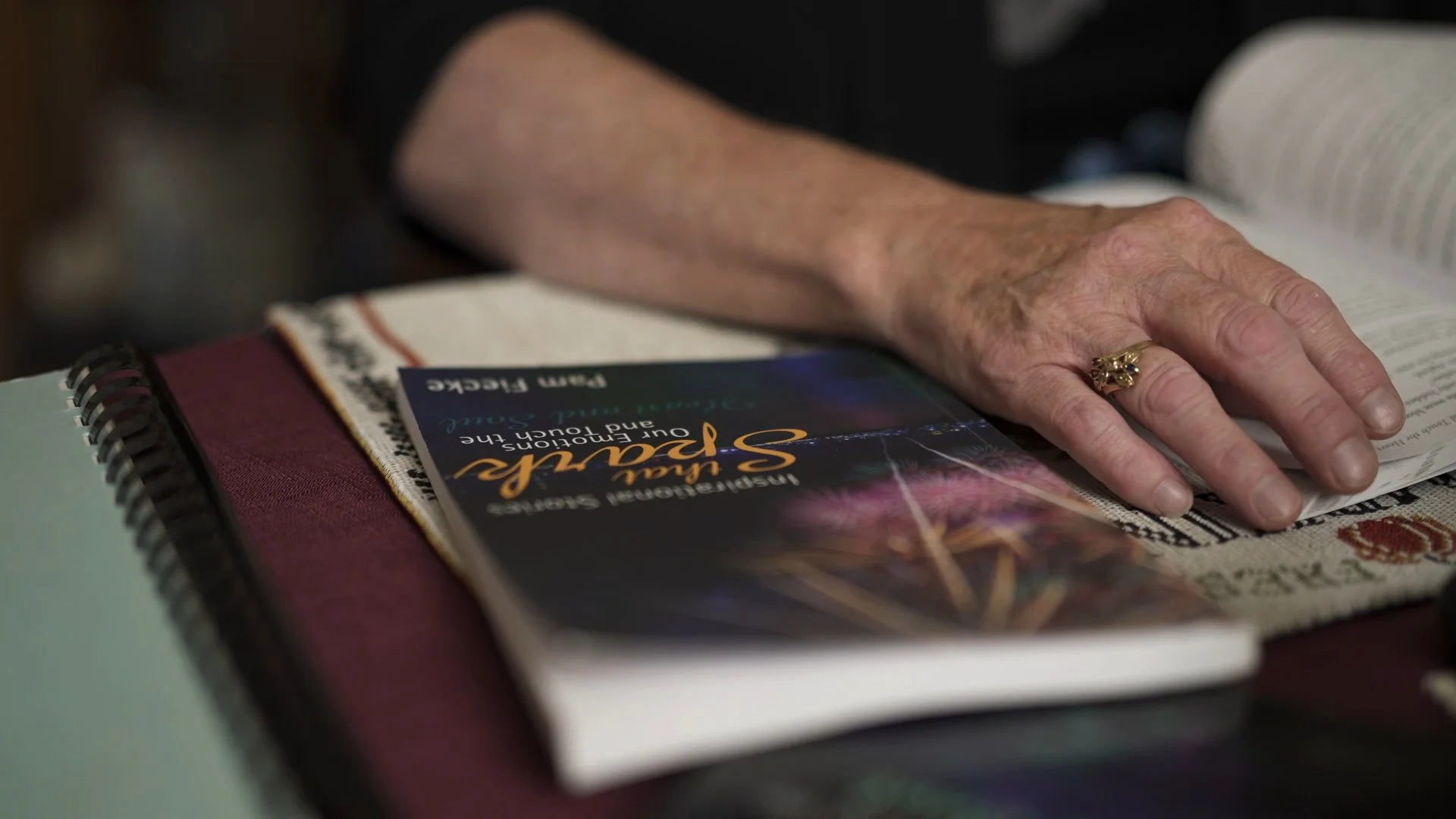 Pam Fiecke shows us her book. A still image from her interview video to promote her book, "Inspirational Stories That Spark Our Emotions and Touch the Heart and Soul."