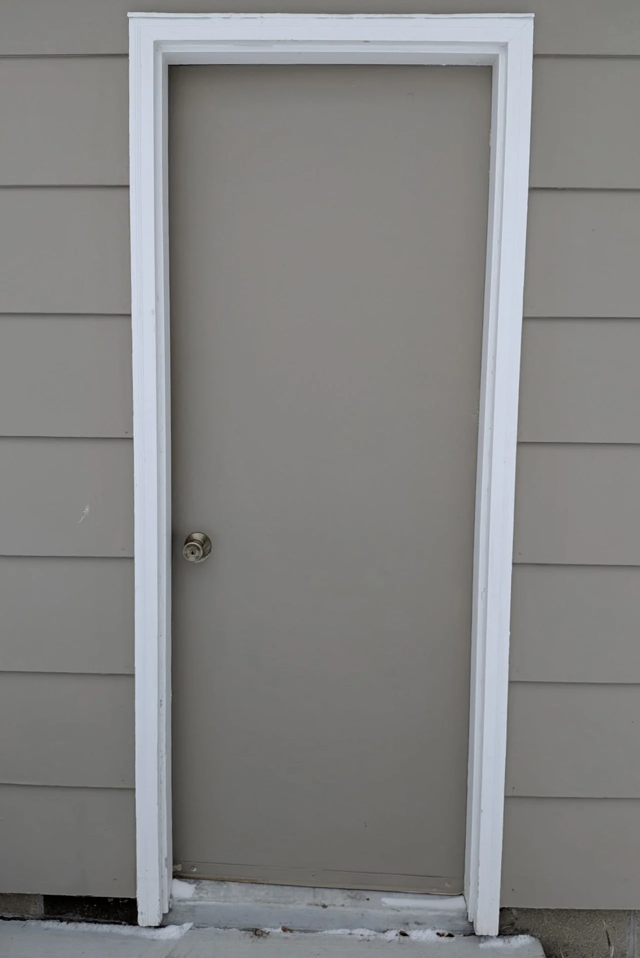 Existing rear garage door and trim prior to replacement.