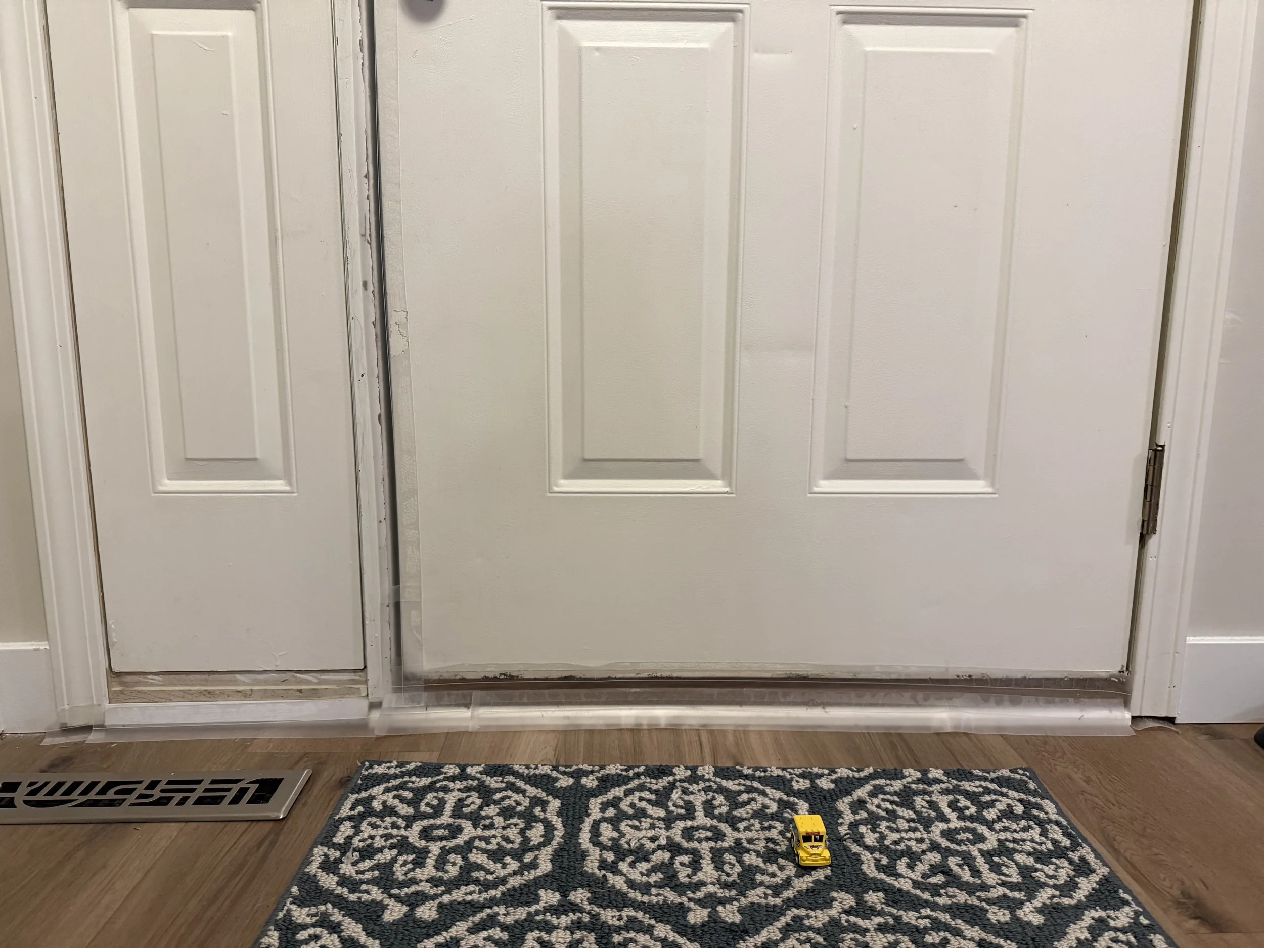 BEFORE: Visual gaps along the bottom of the door, along with unfinished and damaged trim, allowing cold air and drafts to enter the home. 