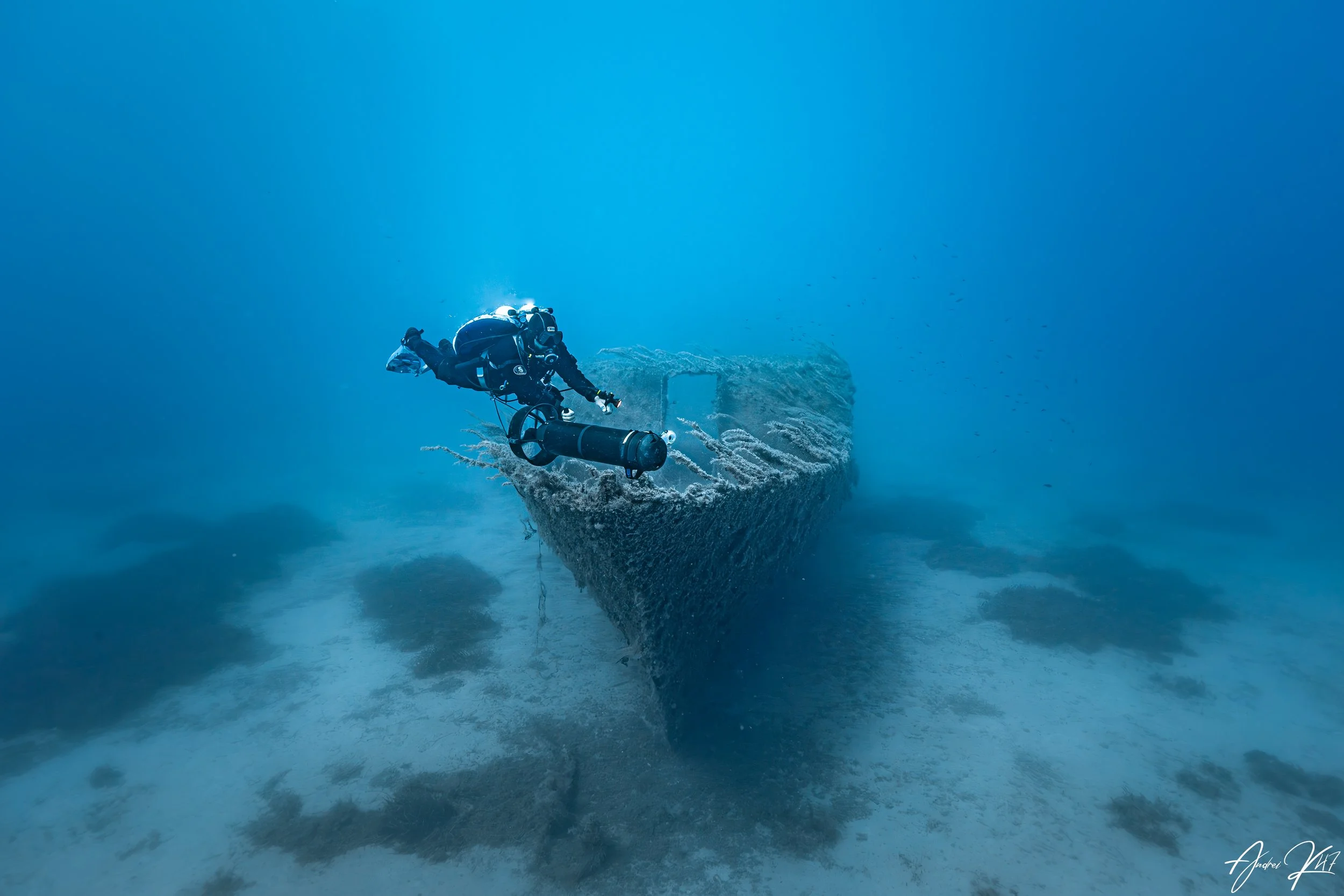 Scuba diver examining a submerged structure on a wreck dive in Cyprus, promoting advanced specialty diving courses.