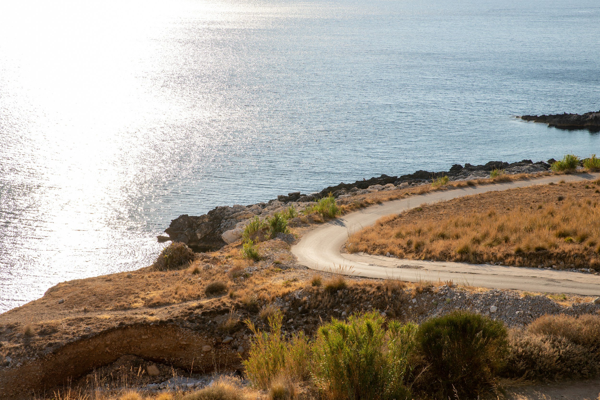Coastal road near Protaras, Cyprus, leading to the sea at sunset.