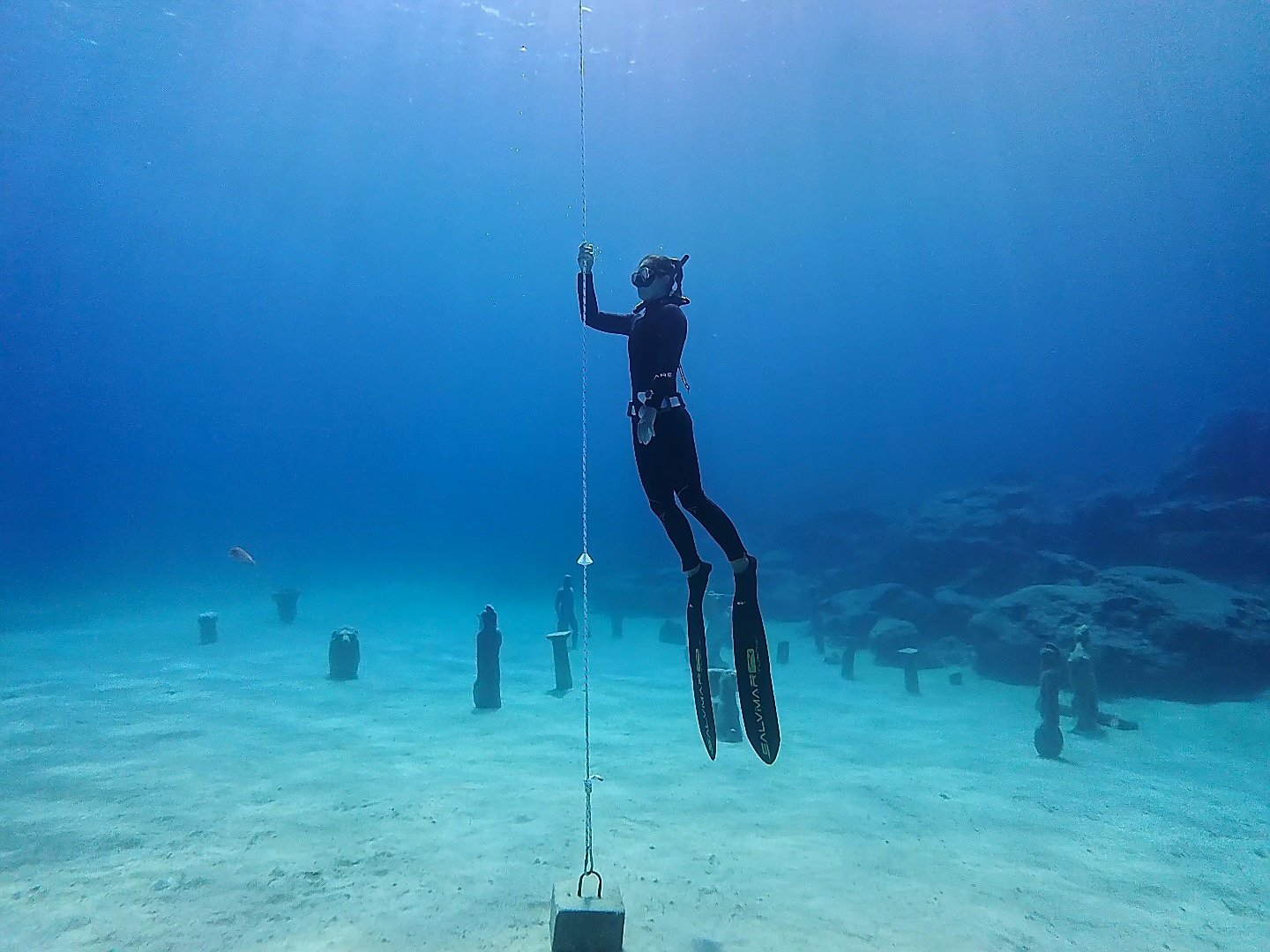 Freediver descending along a rope in clear blue water near Protaras, Cyprus, during a Try Freediving session.