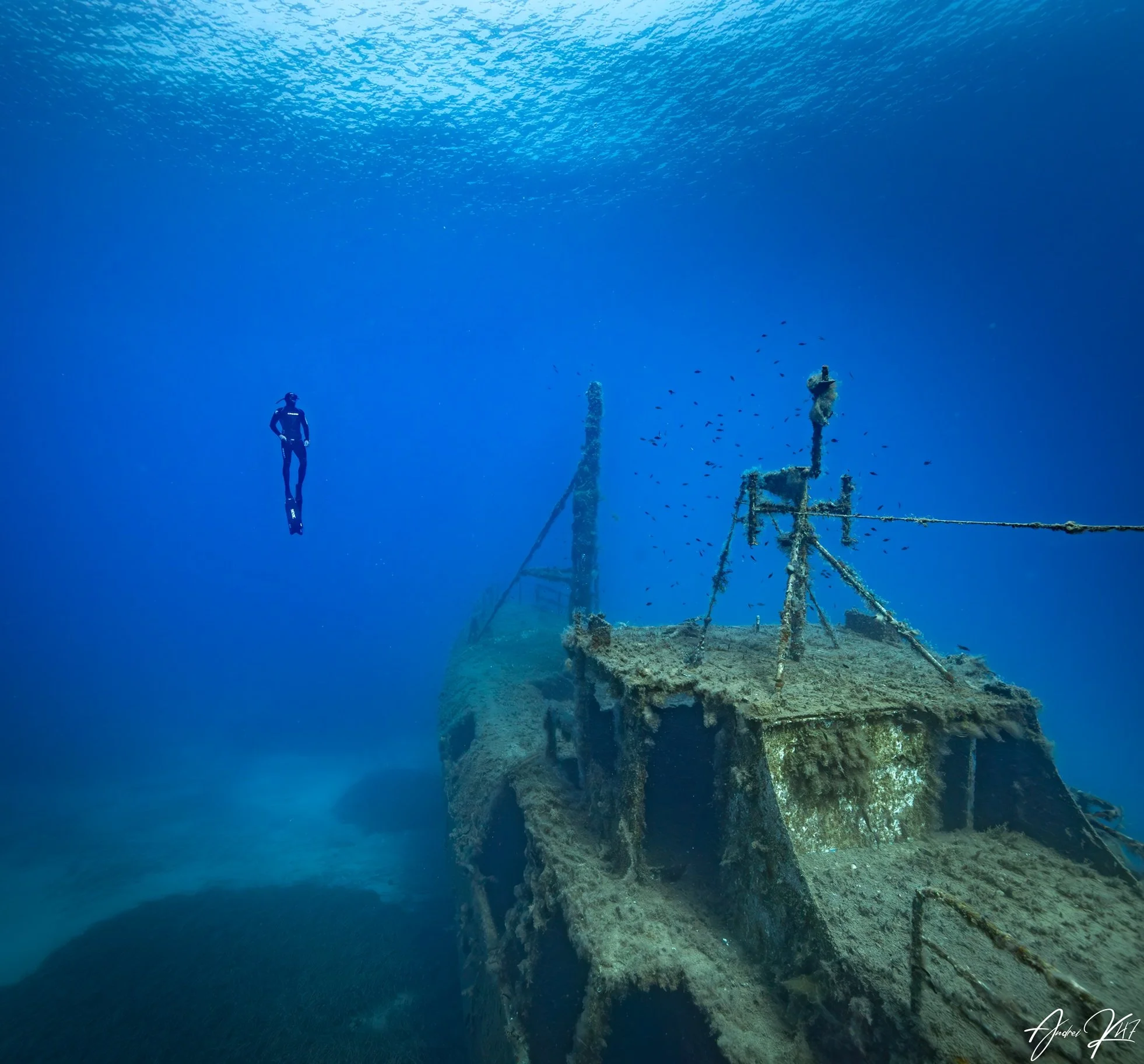 Freediver exploring an underwater structure surrounded by blue water near Protaras, Cyprus, during a recreational fundive.