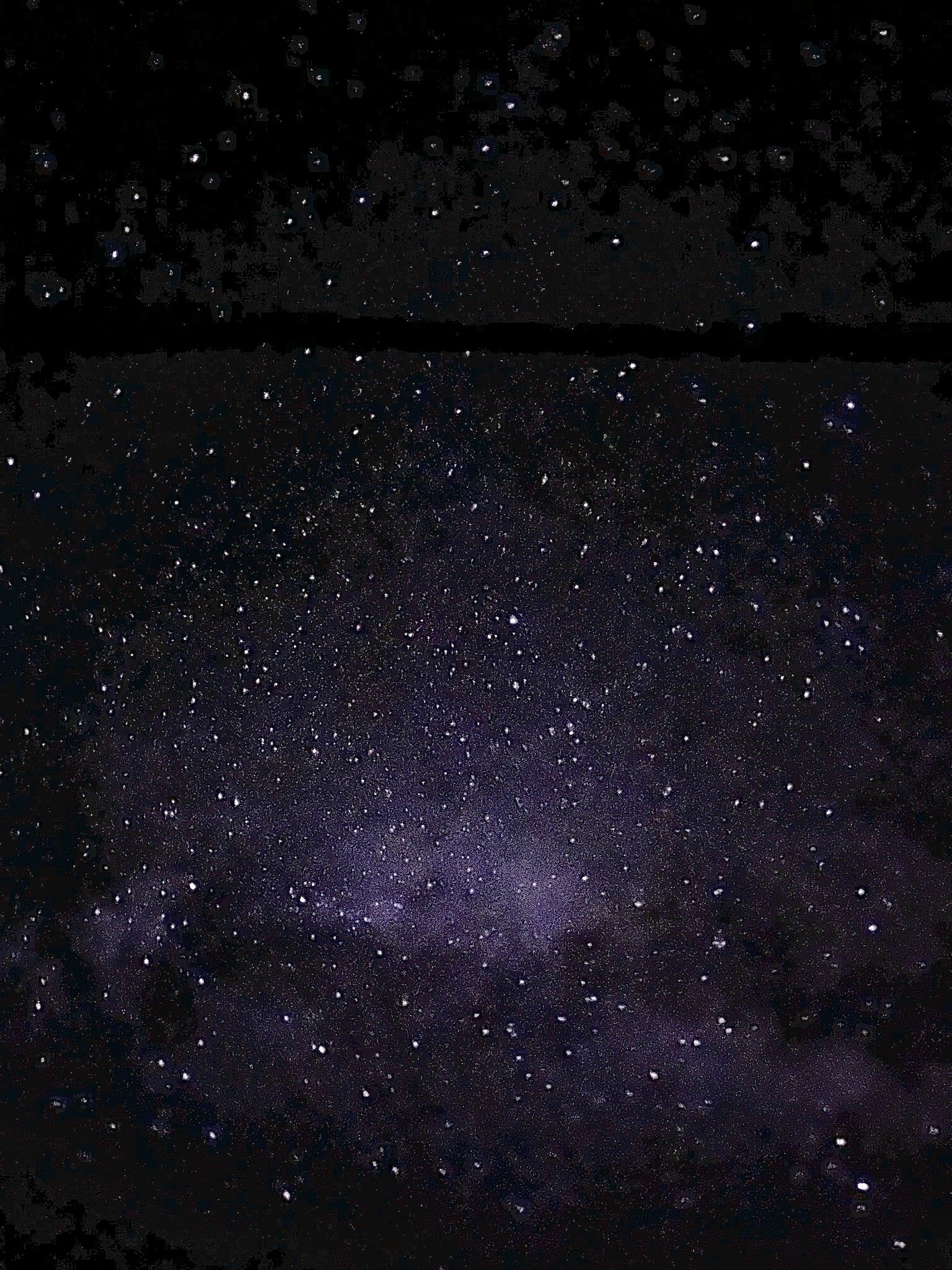 Nighttime sky filled with countless stars and the Milky Way galaxy visible across the dark sky.