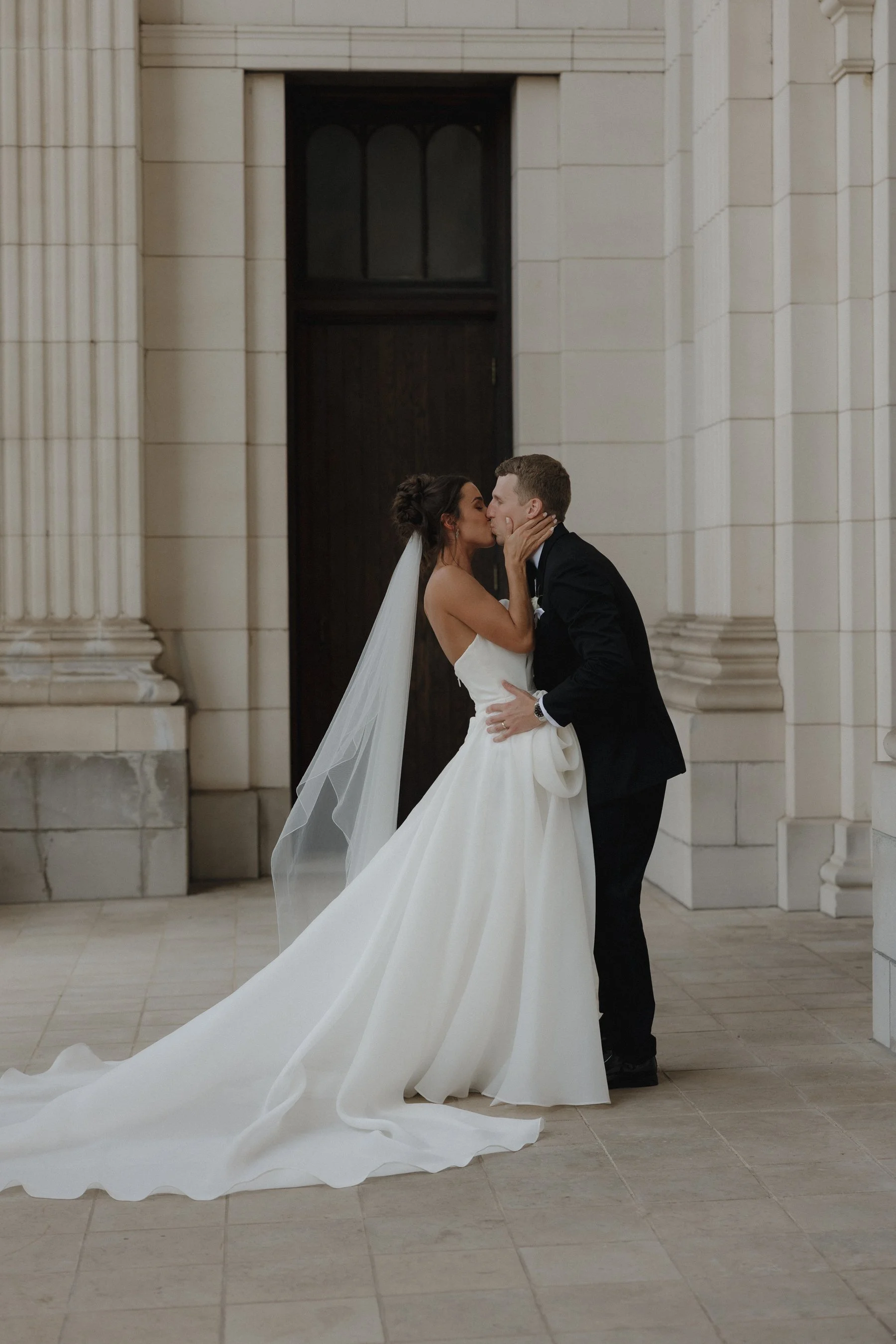 A bride and groom kissing outside the church of their ceremony. Chicago church. Chicago wedding photographer
