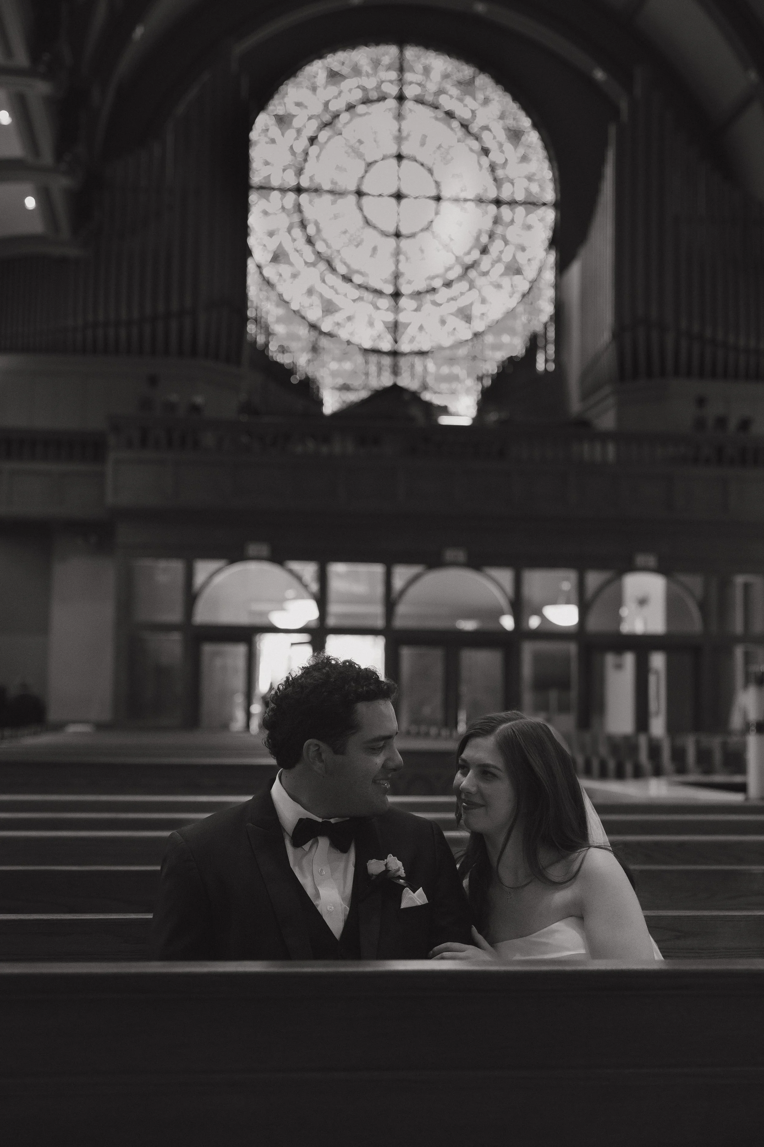 A bride and groom sitting in a church looking into eachothers eyes after their wedding ceremony