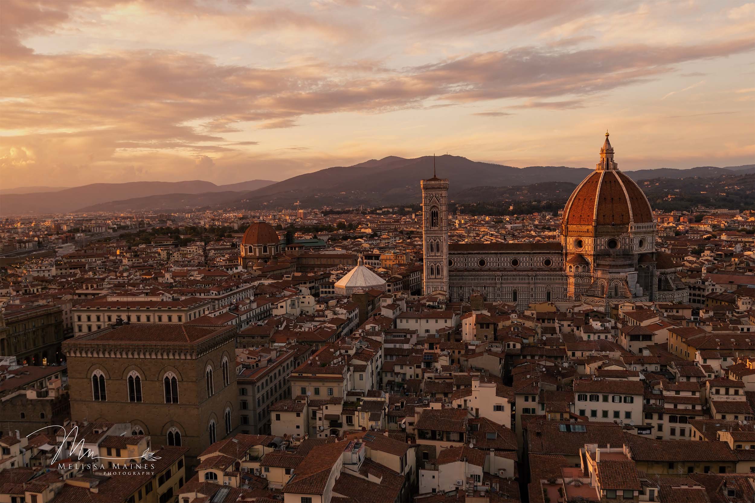 Aerial view of Florence, Italy, at sunset featuring the famous Il Duomo Cathedral with its large dome.