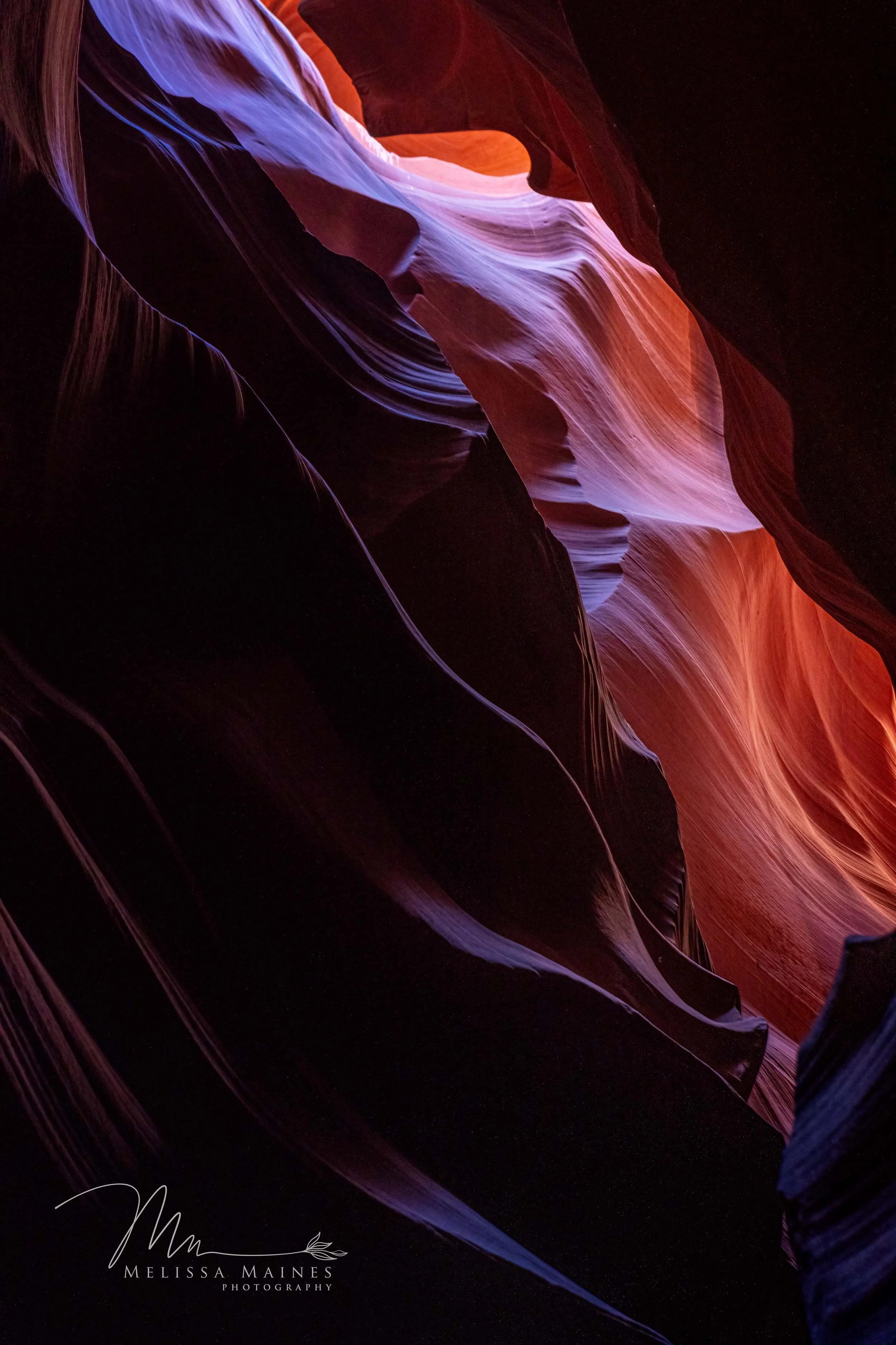 Colorful Northern Antelope canyon with rock formations in shades of red, orange, pink, purple, and blue.